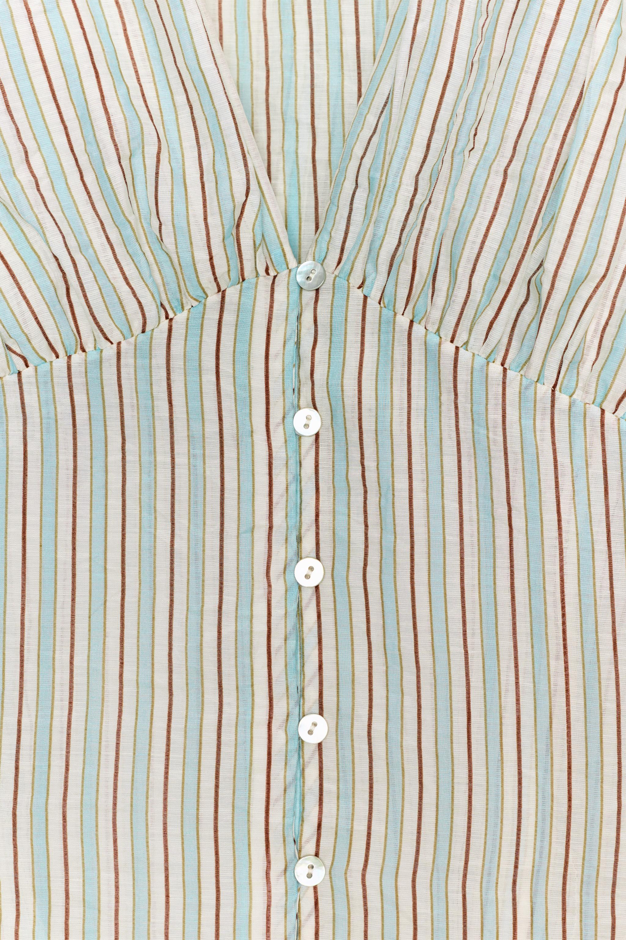 V-neck shirt with long sleeves. Featuring a fitted waist and button-up front. | Zara DE