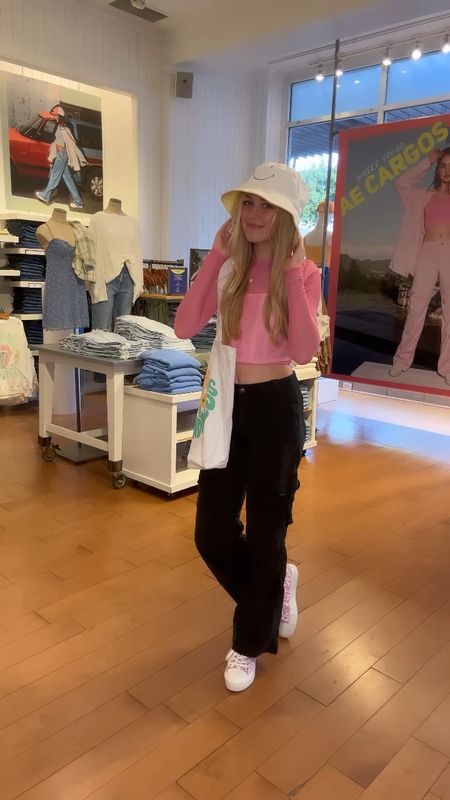 Pink sheer long sleeve with black cargo pants and white corset top looks so cute with this Choose Kindness bag and smiley face bucket hat!😃💛 

#LTKunder50 #LTKBacktoSchool #LTKunder100