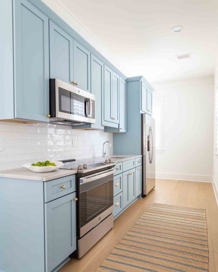 Our carriage house kitchen with Aero Blue cabinets, brass cabinet hardware, a blue striped jute rug and simple white subway tile. Take the full tour of the carriage house here: https://lifeonvirginiastreet.com/florida-new-build-progress-part-iii/.
.
#ltkhome #ltksalealert #ltkseasonal #ltkfindsunder50 #ltkfindsunder100 #ltkstyletip

#LTKsalealert #LTKSeasonal #LTKhome