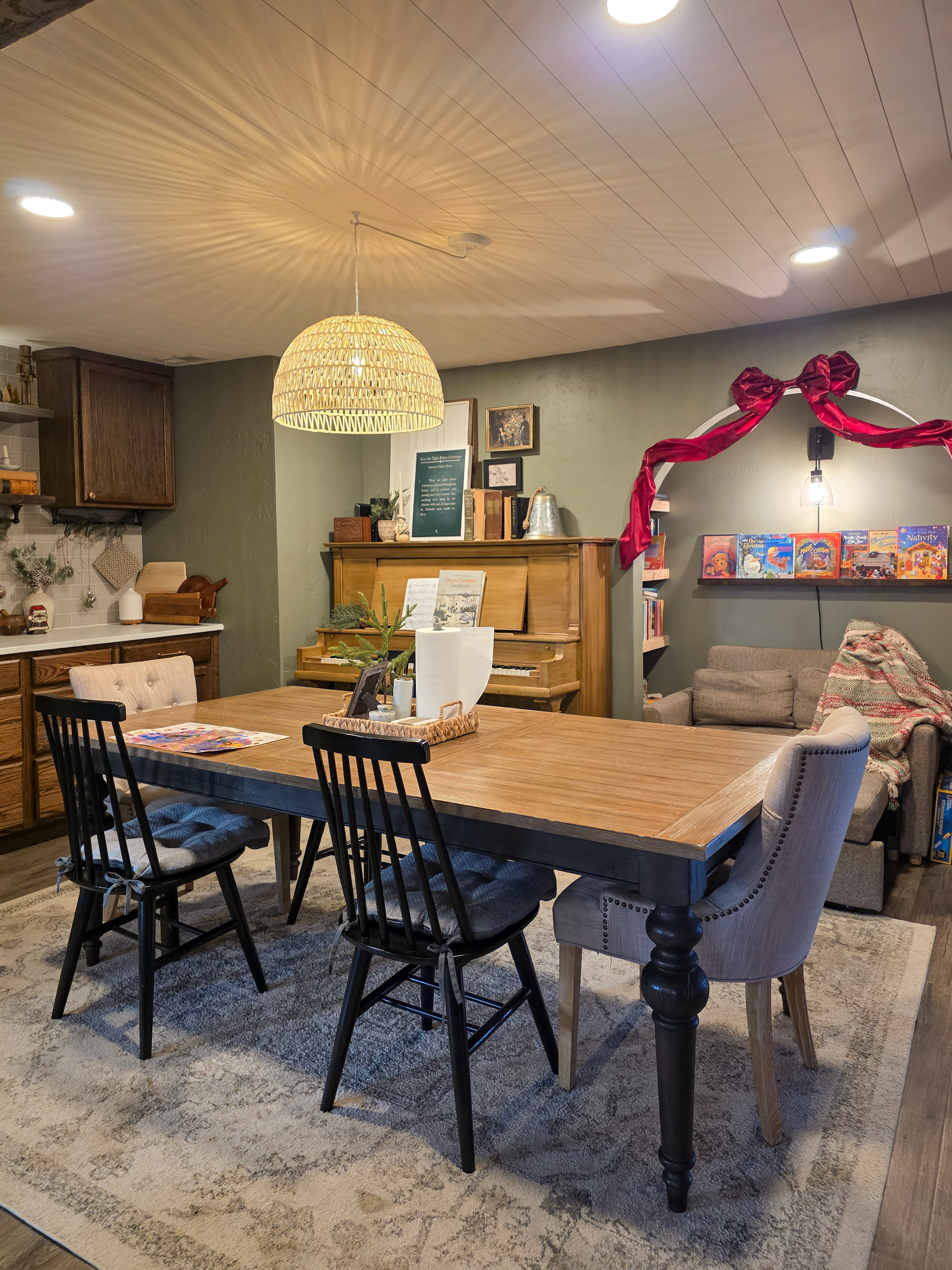 Cozy Christmas dining room: A tiny faux tree on the table and a big satin red bow over the archway. Even the art above the piano got a holiday swap. Easy and charming. 

 #LTKHoliday #LTKHome #LTKFindsUnder50