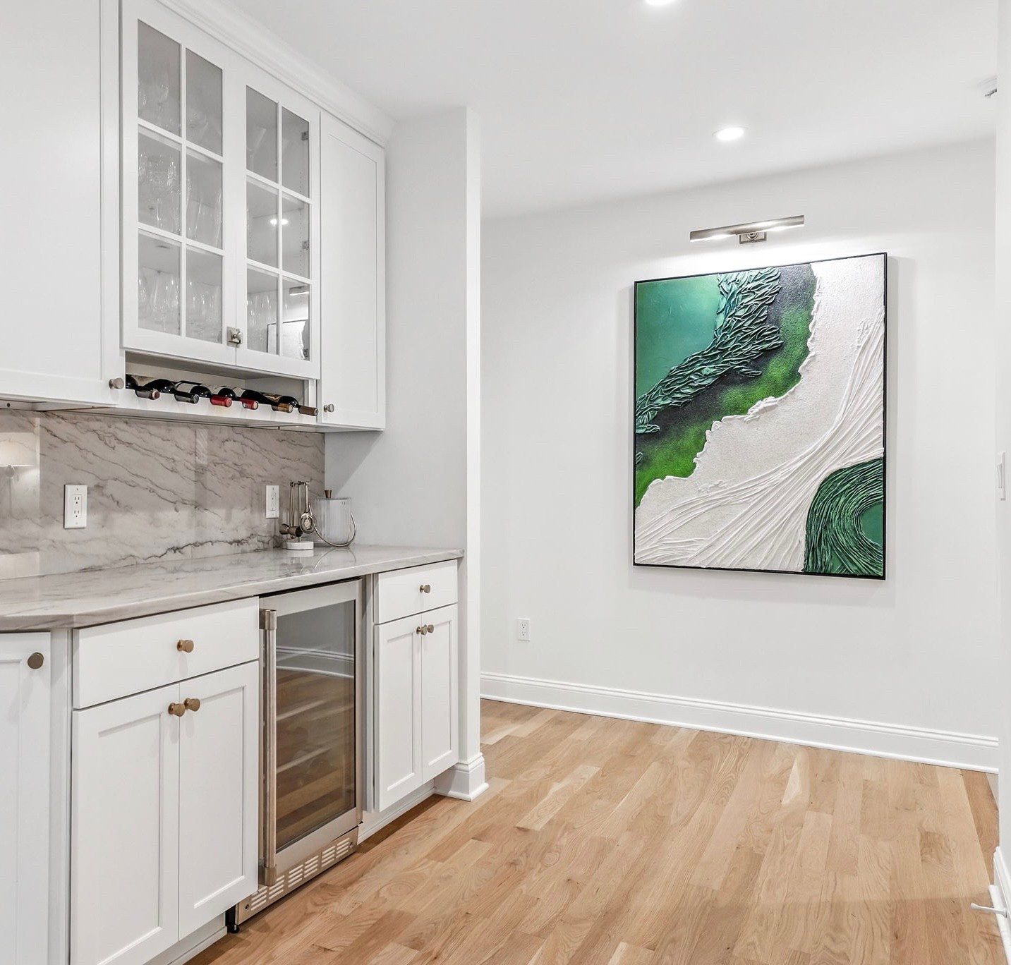 A beautifully layered mix of texture, color, and contrast sets the tone in this bar area. The striking green canvas brings a vibrant energy that anchors the space and sparks conversation. It’s the perfect backdrop for a curated cocktail moment.
