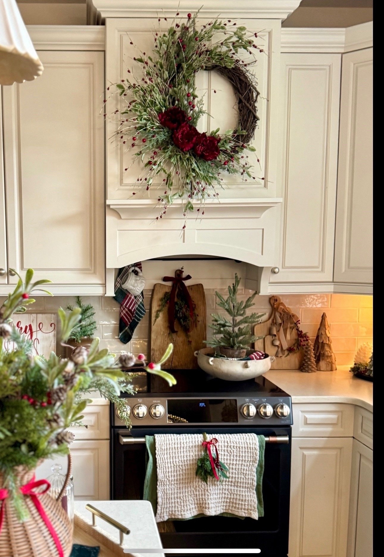 Christmas kitchen! Recreate this festive look with my beautiful 24” winter wreath with greenery, red berries and florals currently on sale. Also, my favorite rustic tabletop tree, gold bells, green and red plaid napkins, mini swags set of 4, waffled towels, bread board, white Santa mug, viral woven planter, red ribbon, and Christmas greens.  Also sharing the black magnetic curtain rod I used on the back of our oven in place of a pot rail. The bottom piece of our custom vent hood is metal so this worked so well bc we didn’t have to drill holes in our brand new vent hood. I hang my decor off of black S hooks. I will be sharing a better photo of this soon  

#LTKSeasonal #LTKHome #LTKHoliday