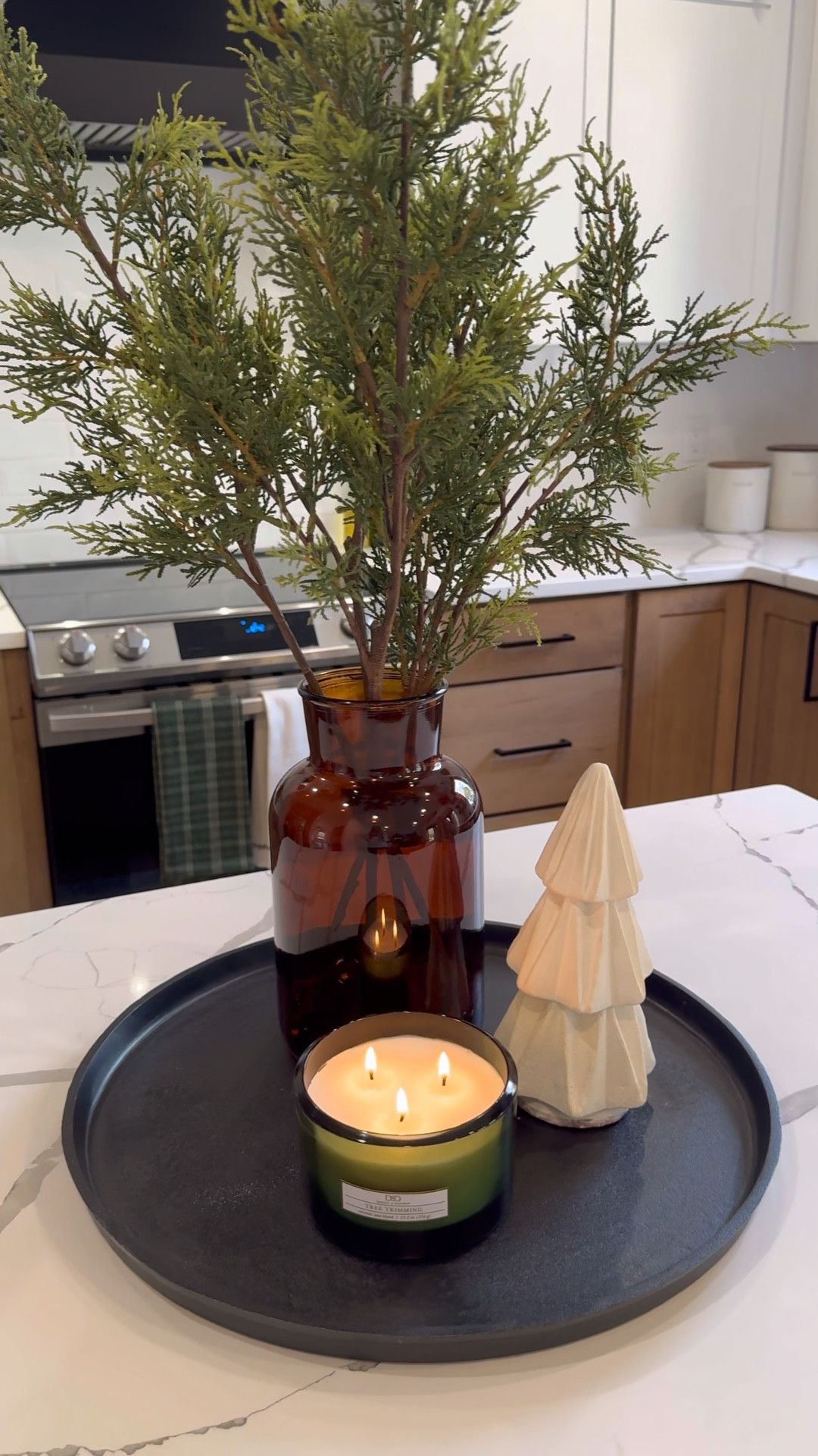 Christmas centerpiece idea! This cast iron circular tray is so nice if you love black accents like I do! I added a faux arrangement with a brown glass vase + a white ceramic Christmas tree 😍 and of course a candle! I found this one at hobby lobby 🕯️ 

#LTKHoliday #LTKHome #LTKVideo