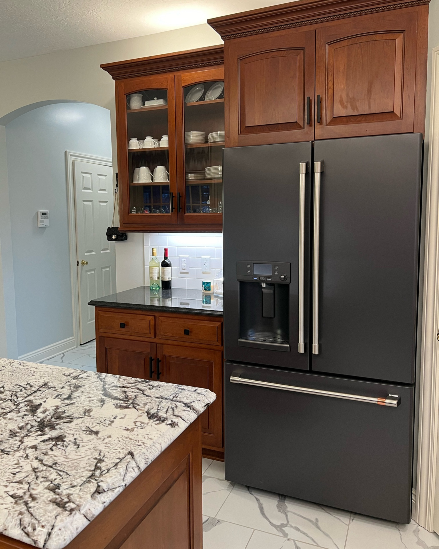 Kitchen remodel. Linking marble tile, granite on perimeter and the kitchen island, and cafe fridge. 

Kitchen after. Cherry kitchen cabinets. 2024 kitchen remodel. Kitchen design. Kitchen before and after. Kitchen inspiration. Kitchen ideas. Black and white kitchen. 

#LTKhome