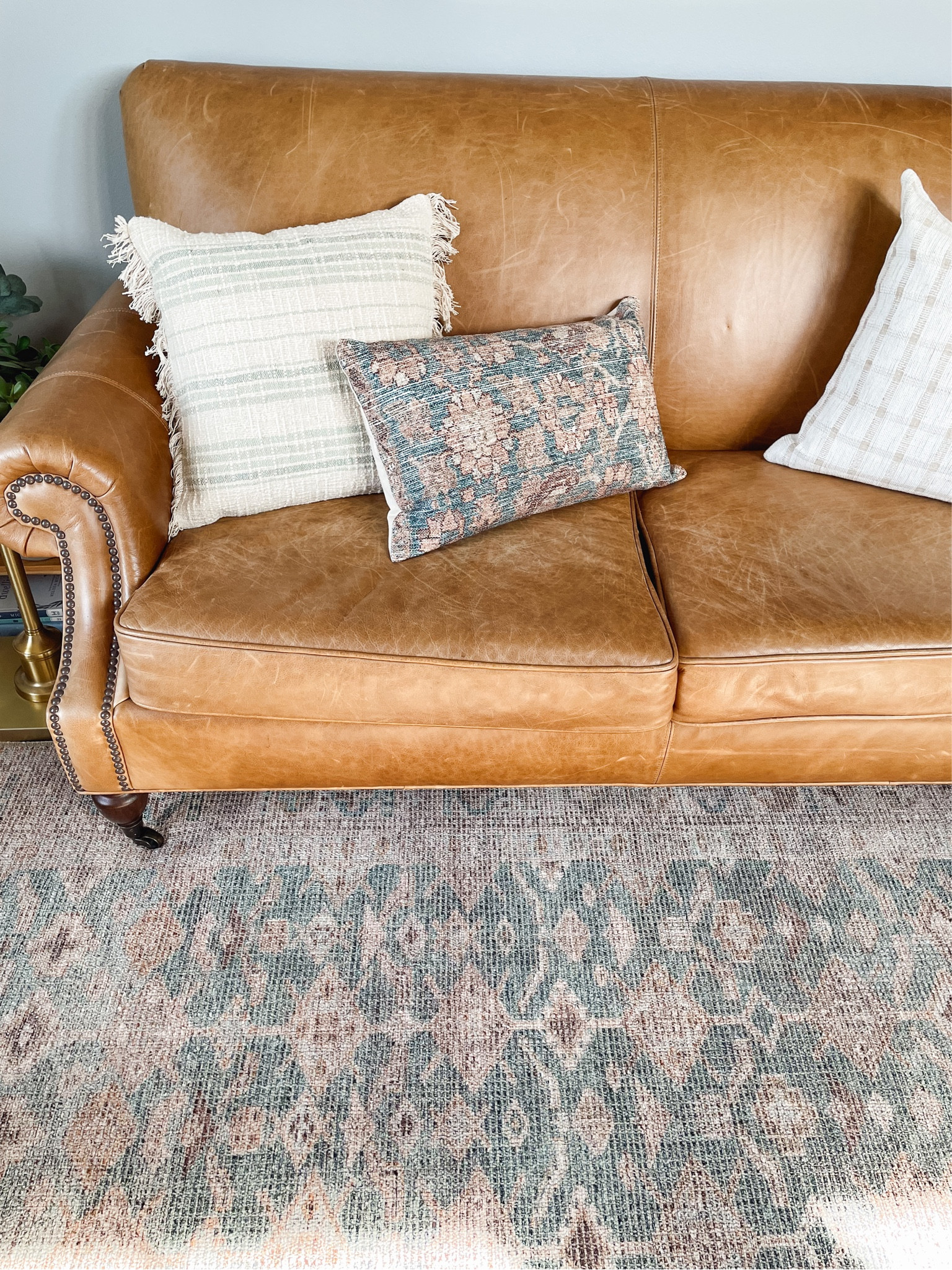 Leather sofa, patterned mix and match pillows, vintage inspired patterned rug

#LTKhome #LTKstyletip #LTKSeasonal