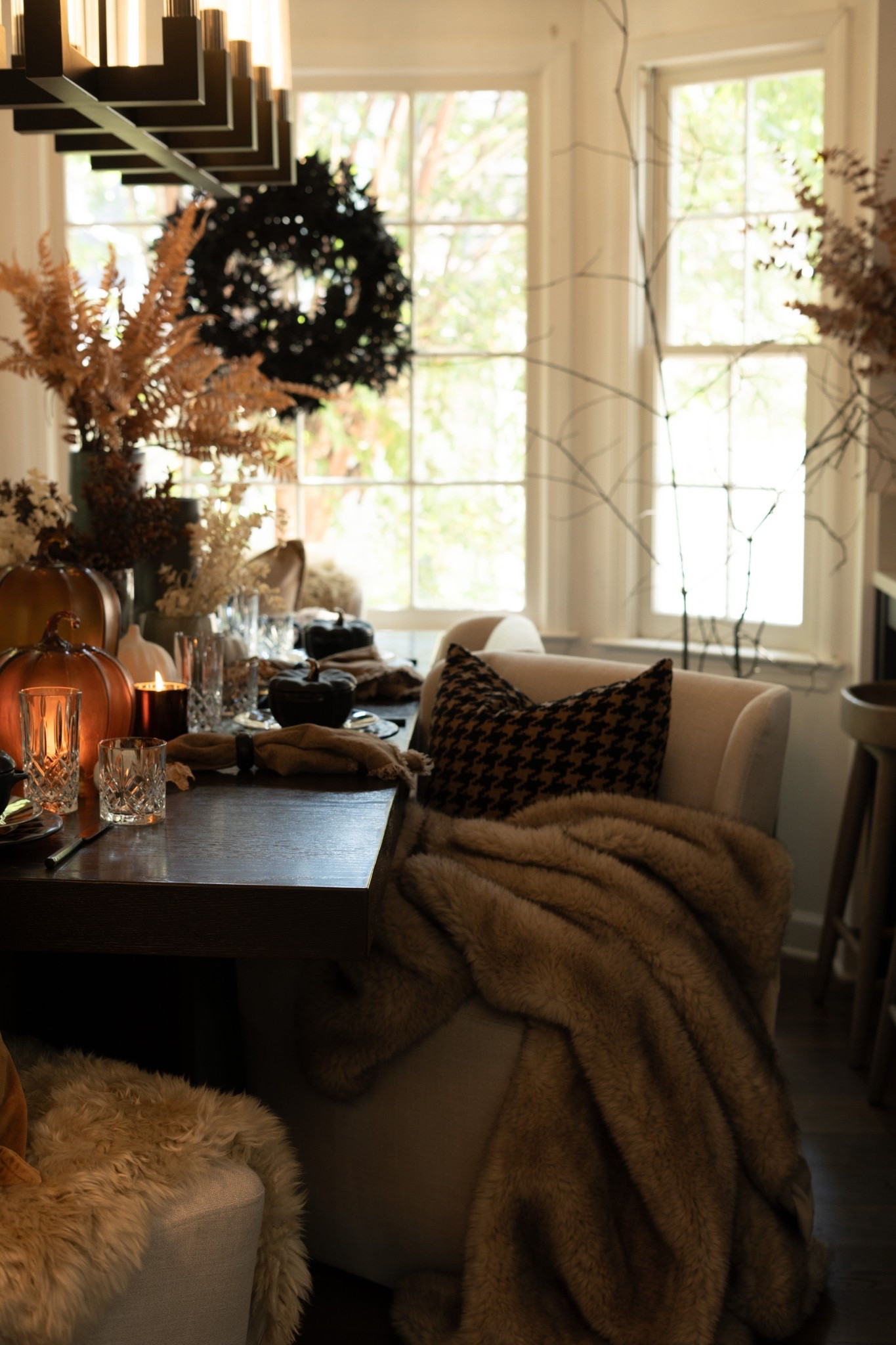 This cozy corner is fall perfection! I layered plush throws, warm candlelight, and bold textures like houndstooth and velvet to create a space that feels like a warm hug. The table is set with moody, modern details and glowing pumpkins that bring in that magical autumn glow. And that black wreath in the window? Total statement piece. It’s the kind of space that makes you want to sip cider and stay awhile! 

 #LTKSeasonal #LTKHome #LTKStyleTip