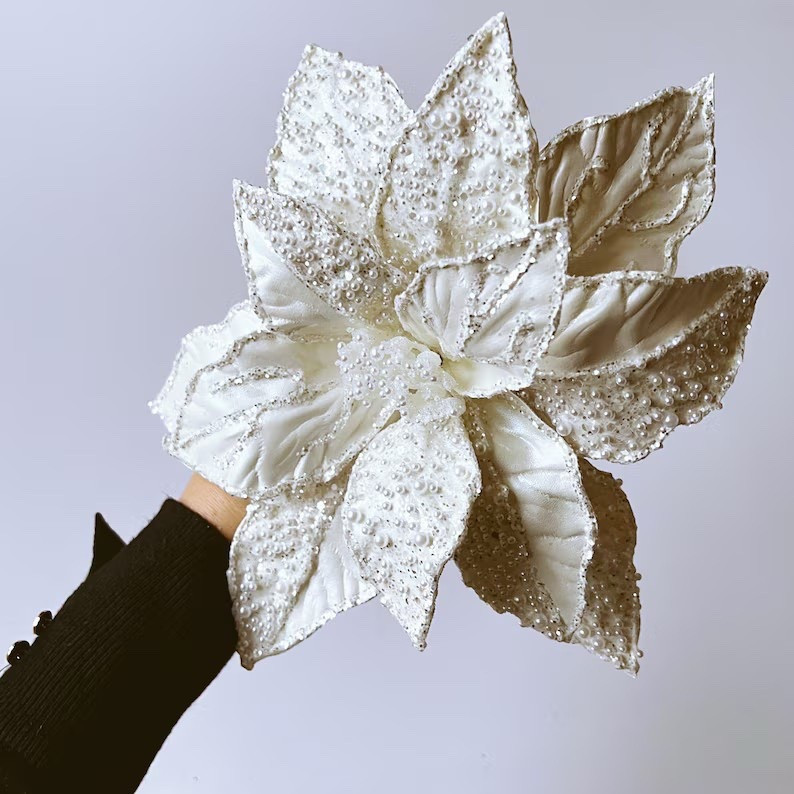 Make a statement this holiday season with this luxe white poinsettia stem from PaulettaStore 🤍 Featuring delicate white petals with shimmering glitter and pearl accents, this bold artificial bloom adds instant elegance to any Christmas décor. The wired, bendable stem and petals let you style it exactly how you like—perfect for wreaths, centerpieces, seasonal bouquets, tree décor, or a simple vase moment. A timeless holiday accent you’ll reach for year after year.

#LTKhome #ChristmasDecor #HolidayFlorals #Poinsettia #WinterDecor #FloralDecor #EtsyFinds #FestiveHome

#LTKHoliday #LTKSeasonal #LTKHome