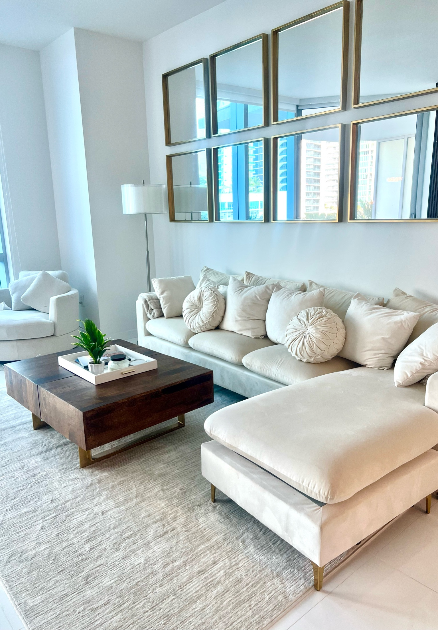 Beige cream velvet sectional with extra throw pillows. Love the added depth by using the walnut extendable coffee table. I painted the legs gold on this piece. The swivel chair linked was what’s now replaced the one I ordered. I also painted the mirrors on the wall. Amazon, Wayfair 

#LTKhome