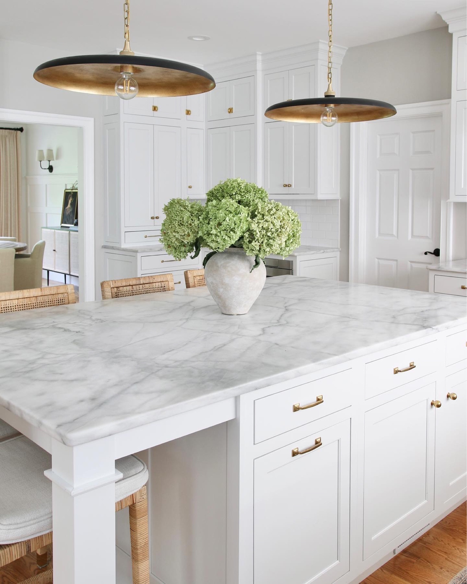 A view from my kitchen island to the dining room, includes Paitto large pendant lights, brass drawer pulls and knobs and rattan counter stools

#LTKstyletip #LTKFind #LTKhome
