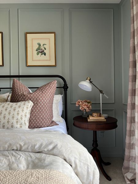 Blue green bedroom with plum colored pillows // cozy bedroom // cozy core bedroom // wrought iron bed // buffalo plaid curtains // floral art over bed // cream bedding 

#LTKhome