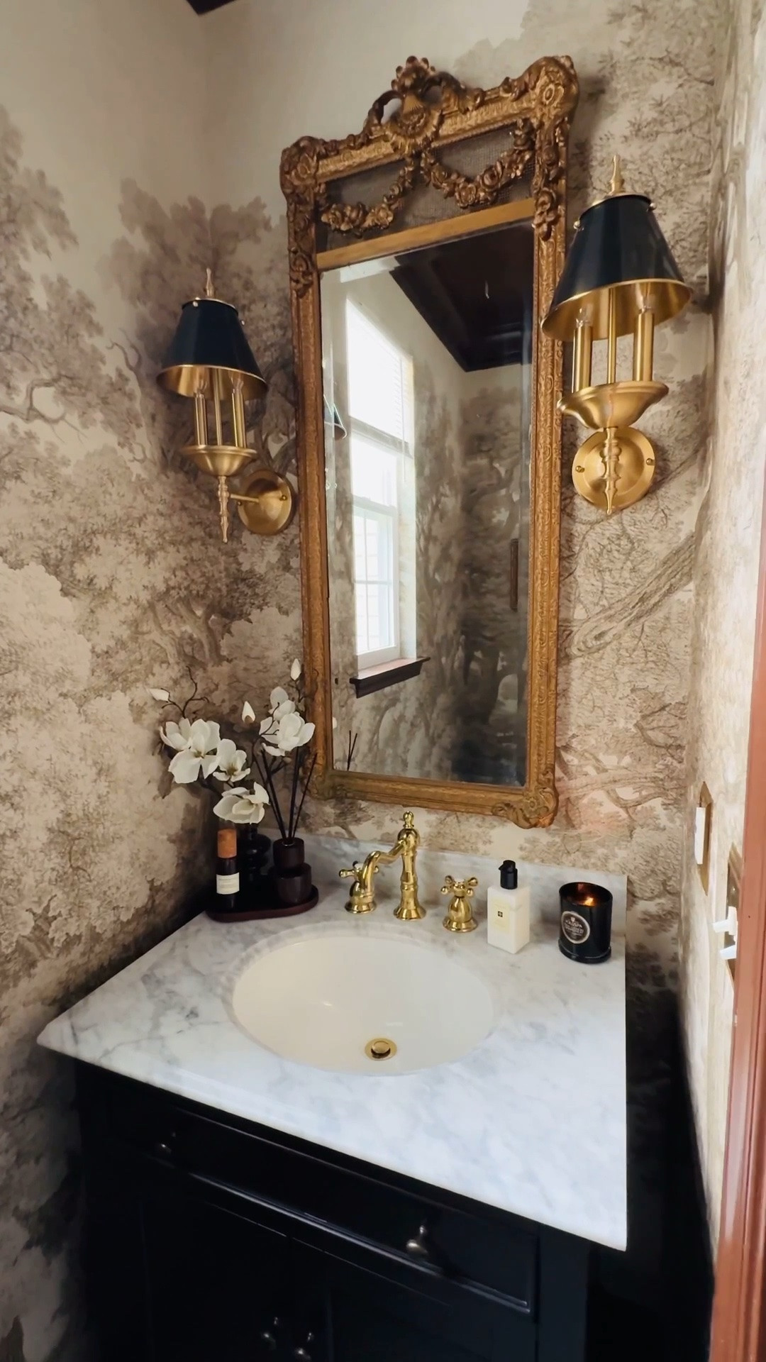 Life is too short to live with “just fine.”

This powder room was fine before… but it wasn’t me and felt a little out of place in our home.

I’ve always believed a powder room is the perfect place to let your imagination run wild. It’s small, unexpected, and one of those spaces where you can really have fun with design.

My vision for this room was a timeless European escape with that classic Ralph Lauren-inspired feel that eluded something moody, warm, and a little bit enchanting.

We added this beautiful wallpaper and painted everything else in Sherwin-Williams Otter at 70% including the crown moulding, ceiling, and even the interior door.

I wanted it to feel almost like an enchanting old-world castle bathroom — rich, cozy, collected, and completely timeless.

And I think we definitely nailed it.

Because sometimes “fine” just isn’t enough when you can create something that feels completely like you.

Wallpaper is "" by Rebel Walls
Vanity is from @Wayfair  
Paint color is "Otter" at 70% by Sherwin Williams.
My stunning mirror was an amazing antique store find!

#LTKSeasonal #LTKHome #LTKSaleAlert