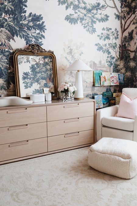 Our daughter’s nursery with a six drawer dresser as a changing table! This oak dresser is on sale, right now. We love how big it is and it’ll grow with our daughter for years to come! The ivory glider is performance fabric and incredibly comfortable. Accessorized with an oversized mirror, linen table lamp and faux florals  

#LTKhome #LTKsalealert #LTKbaby