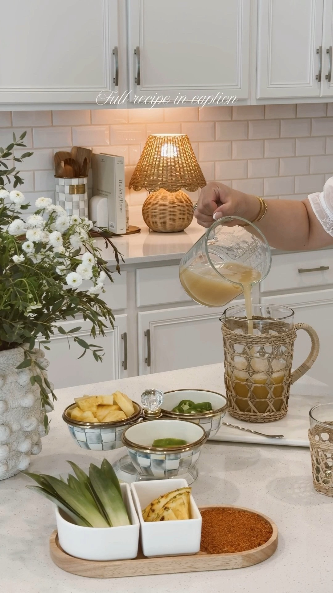 Recipe:

For an easy even-measure pitcher recipe (close to 42 oz total), do:

* 2 cups tequila
* 1 cup pineapple juice
* 1 cup fresh lime juice
* ½ cup triple sec
* 2 Tbsp agave syrup
* 2–3 cups pineapple chunks
* 10–12 jalapeño slices
* Tajin
* Ice

Instructions:
1. (Pitcher) Mix the Pineapple Juice - Lime Juice - Triple Sec - & Agave Syrup.

2. (tray) Cut chunks of pineapple and slices of jalapeños. 

3. (To make 1 Margarita): 

- Muddle the fresh pineapple chunks, jalapeno slices, and a tiny pinch of salt in the bottom of a cocktail glass until the pineapple is almost entirely broken down.

- Add the following ingredients to a shaker with ice, shake well, and pour over fresh ice.

* 2 oz tequila
* 1 oz pineapple juice
* 1 oz fresh lime juice
* ½ oz triple sec
* ½ tsp agave syrup
* 2–3 pineapple chunks
* 2–3 jalapeño slices
* Tajin for the rim
* Ice
#bartcart #margaritarecipe #kitchenfavorites #mackenziechilds

#LTKdayinmylife #LTKSeasonal #LTKHome