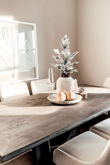 Winter dining table decor. Faux frosted potted evergreen, porcelain serving bowl,  ceramic fire balls, dining room table, velvet & gold dining chairs.

#LTKSeasonal #LTKhome #LTKsalealert