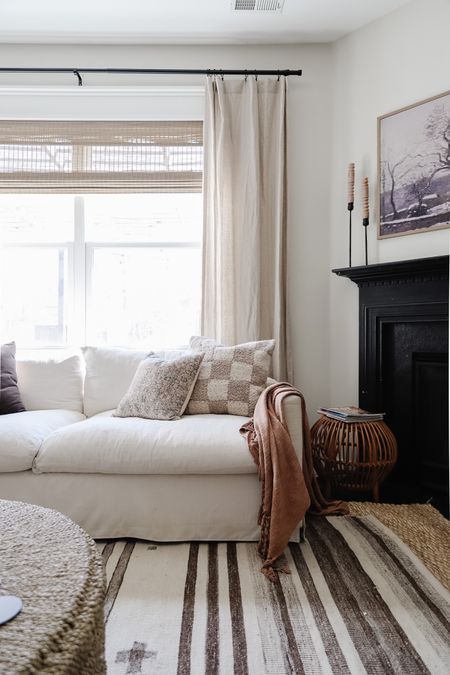 Living room decor, striped brown rug, linen curtains, rattan stool, white sofa, woven drum coffee table 

#LTKhome