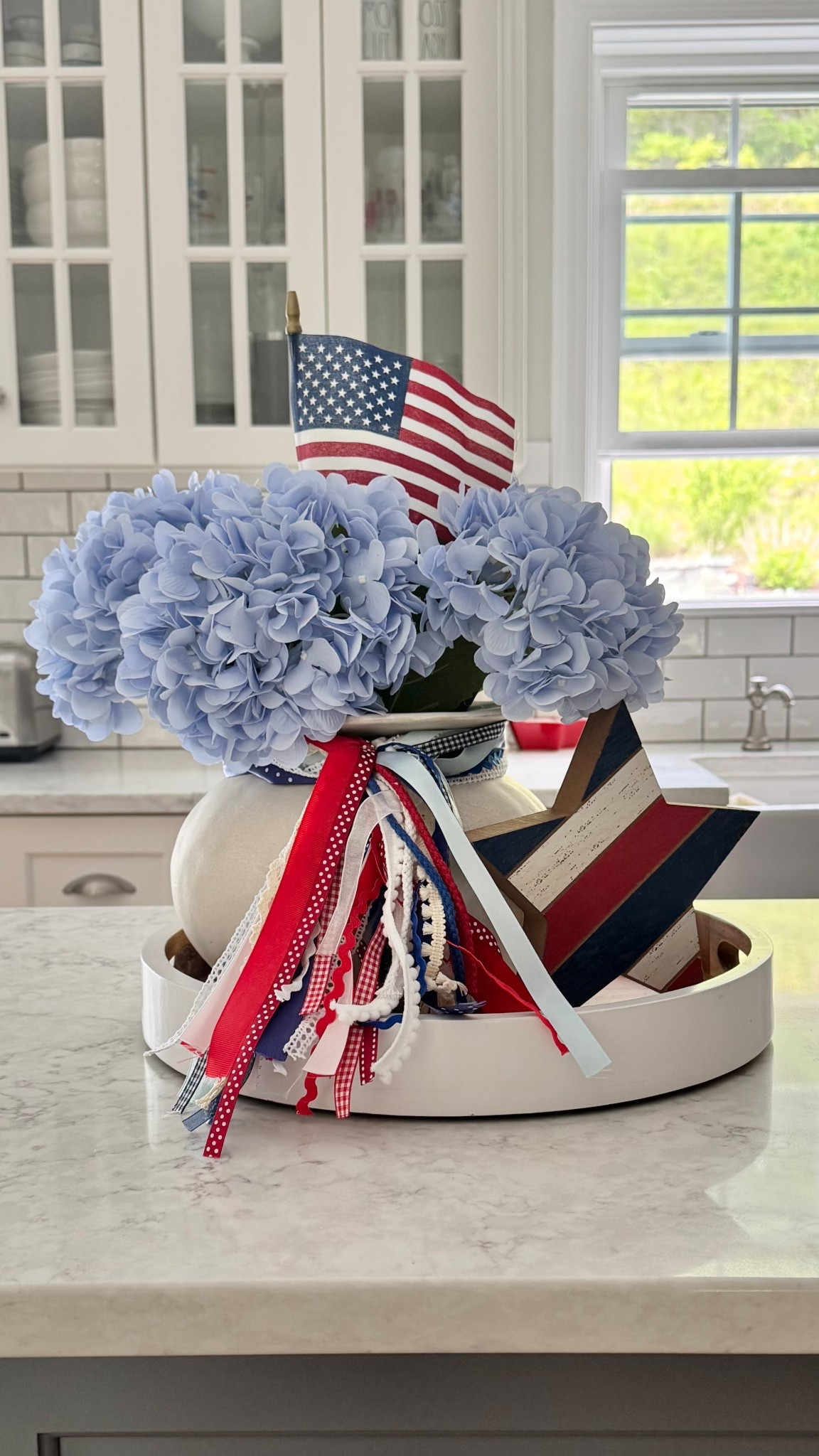 Patriotic Tray Styling - red, white and blue ribbons and a flag at just the right about of red white and blue next to my blue hydrangeas!!

Patriotic decor | Americana | hydrangeas | florals | Fourth of July | trays | kitchen styling | kitchen island 

#LTKSeasonal #LTKHome