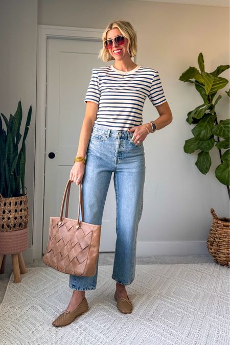 Spring staples stripes! I love the modern touch with the exaggerated shoulder in this T-shirt! I am wearing my true size small. Parrot with a classic light wash, straight leg pair of jeans, neutral, ballet flats, and a woven tote for an effortless elevated spring outfit. 

#LTKstyletip #LTKover40 #LTKfindsunder100
