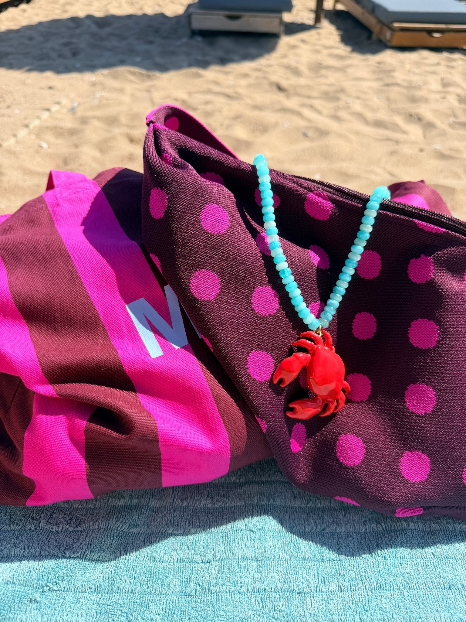 Matchy matchy. Gestreepte shopper of strandtas in roze met bordeaux en een bordeaux met roze gestipte crossbody tas (My Jewellery). Turquoise ketting met krab.