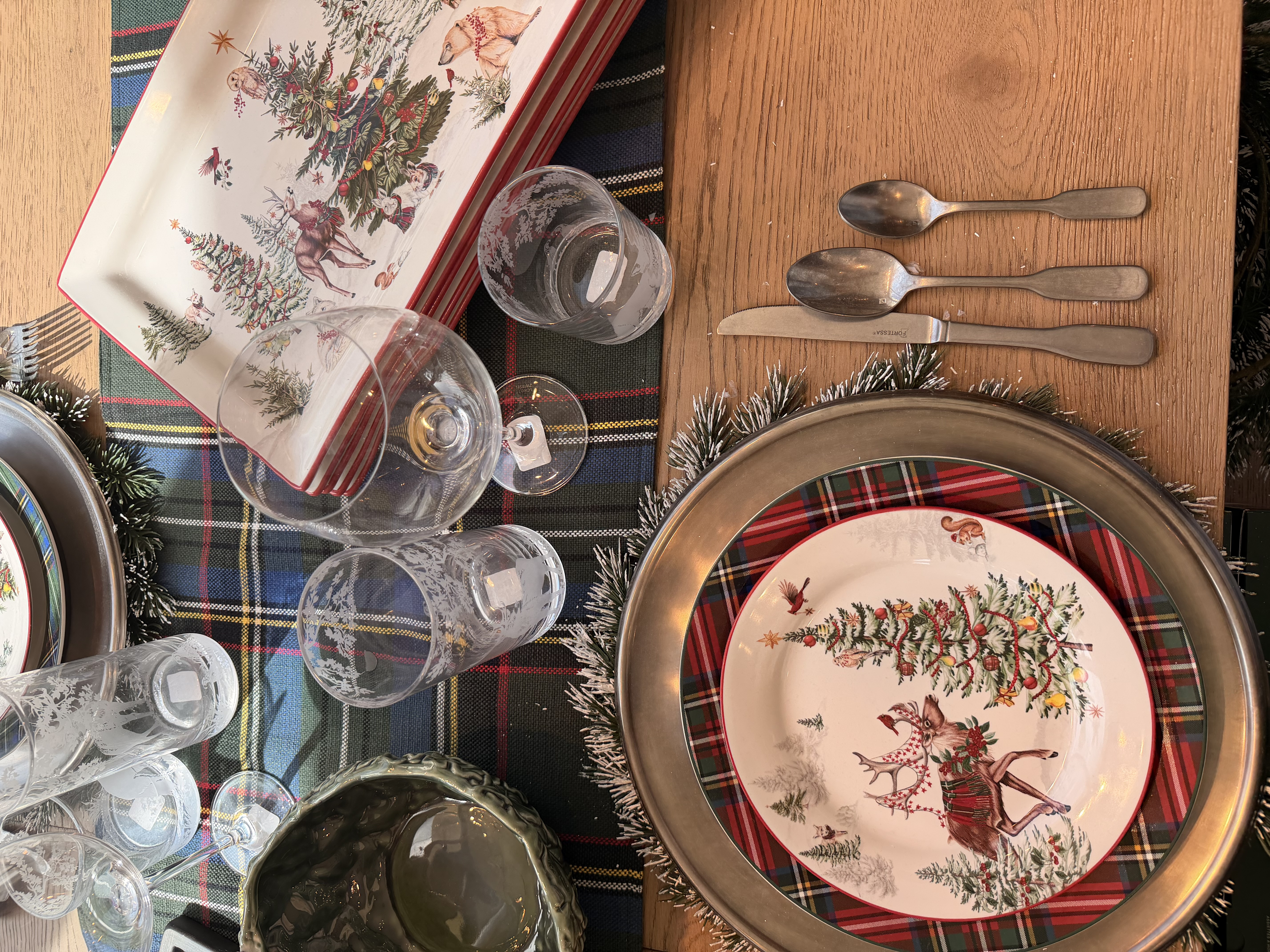 holiday tablescape idea from pottery barn! loving the blue and green plaid table runner for the holidays with the enchanted woods themed holiday plates. the garland wreath for around the charger plate was such a festive touch for a holiday tablescape idea! 

 #LTKHoliday #LTKHome