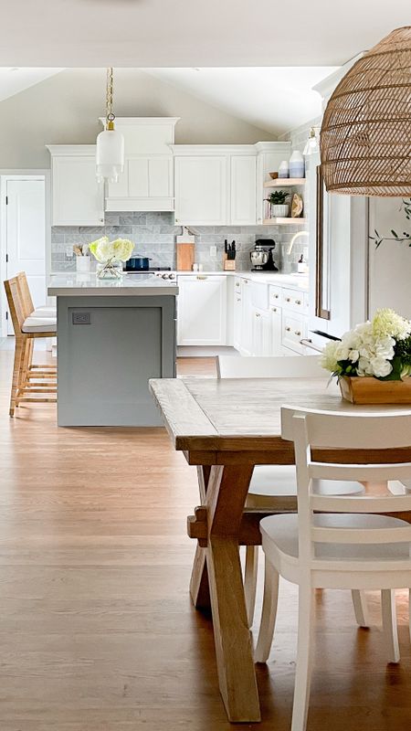 Coastal style kitchen and dining room with white cabinets, gold fixtures, Serena and Lily barstools, pottery barn table, rattan light fixture, and more home decor

#LTKhome #LTKfamily