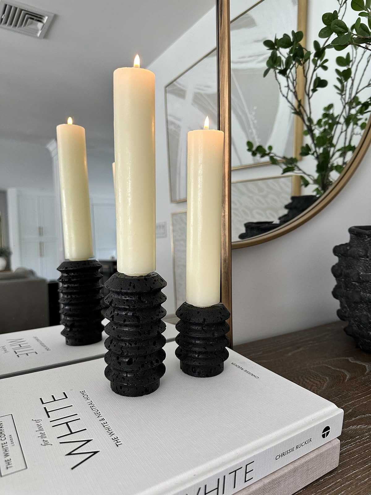 Modern black travertine candlestick holders, wide tapered candles, round mirror, white coffee table  | Amazon (US)