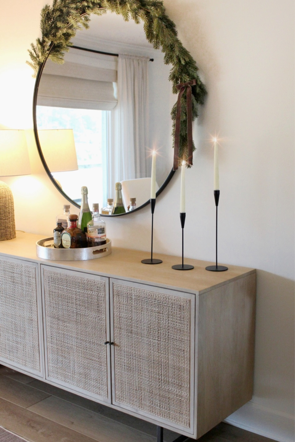 Dining room decor 
Faux candle sticks 
Realistic battery operated candles candle holders rattan cane console table cabinet 
Large round black mirror 

#LTKfindsunder100 #LTKhome #LTKsalealert