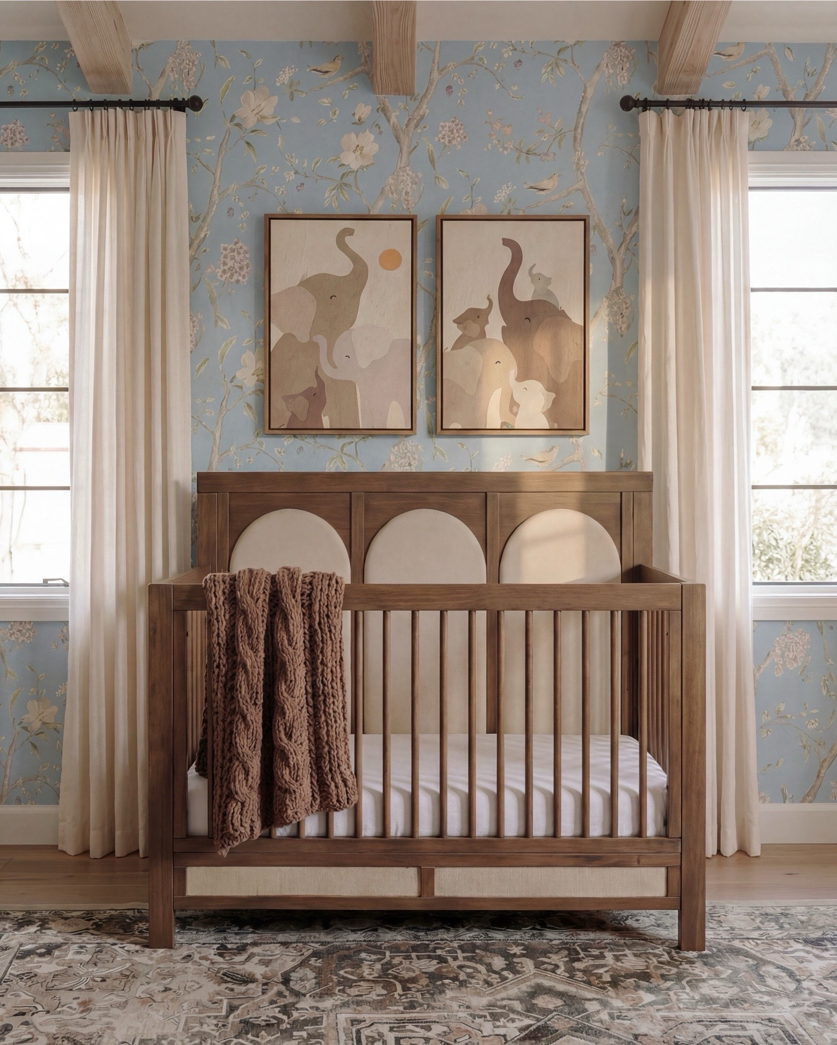 This nursery feels soft, whimsical, and thoughtfully layered—designed to grow with your little one while still feeling elevated and calm. The powder blue floral wallpaper sets a dreamy backdrop, while light wood beams and furniture keep the space warm and grounded. Natural textures, rounded shapes, and gentle curves make the room feel cozy, playful, and serene all at once.

The styling is sweet but intentional—plush wall decor, open shelving for toys and books, and a mix of classic wood pieces with soft textiles create a nursery that feels curated, not cluttered.

Shop the Look:
• Light blue floral wallpaper
• Natural wood exposed ceiling beams
• Solid wood crib (warm oak tone)
• Neutral crib mattress + fitted sheet
• Knit baby blanket (soft brown)
• Vintage-inspired area rug (muted blue + beige)
• Wood dresser with woven drawer fronts
• Round gold-framed wall mirror
• Brass table lamp with white shade
• White boucle accent chair
• Round upholstered pouf (cream)
• Wooden toy shelving unit
• Front-facing wooden book rack
• Children’s board books (colorful covers)
• Plush teddy bear
• Soft cloud wall decor
• Star-shaped wall pillows (neutral tones)
• Crescent moon wall decor
• Beaded rainbow toy
• Sheer white curtain panels
• Black curtain rod with rings
#LTKSaleAlert

#LTKsale #LTKhome