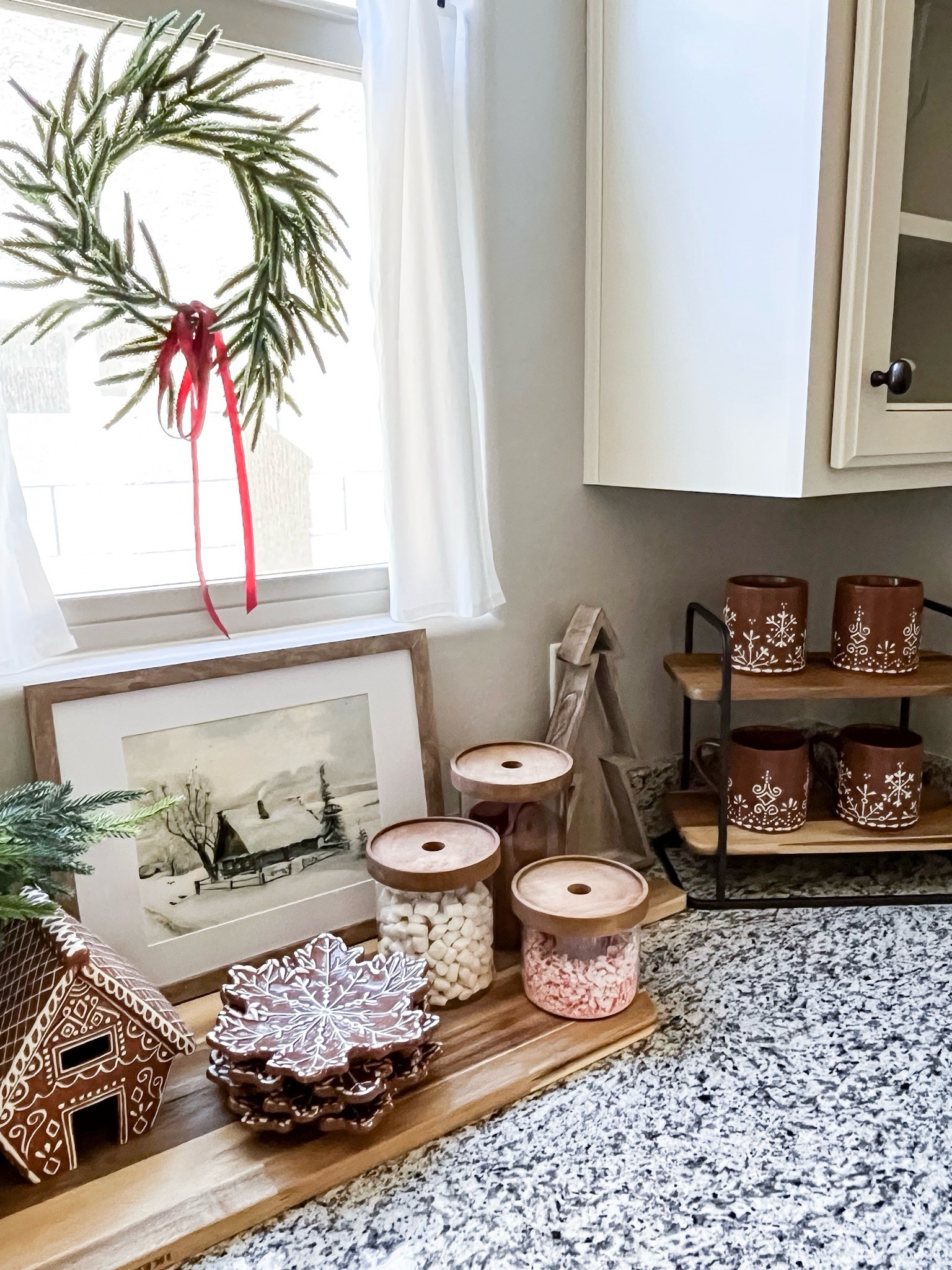 Every year I love setting up a hot cocoa bar and how fun are these adorable gingerbread mugs, plates, and house!!

The art is a digital download I had printed in the 8x10 size. These plastic hooks are amazing for adding wreaths to windows or mirrors. I added the velvet ribbon to the wreath to add a little more touch of red.  

Gingerbread Snowflake
Stoneware Appetizer Plates | Gingerbread
Stoneware Mugs |
Handcrafted
Gingerbread Village
Houses tiered tray shelf | wood trees | Norfolk pine stems | brown ceramic vase | 12 inch Norfolk wreath | wood lid canisters | artwork digital download | 3 pack suction cup hooks | 

#LTKStyleTip #LTKSeasonal #LTKHoliday