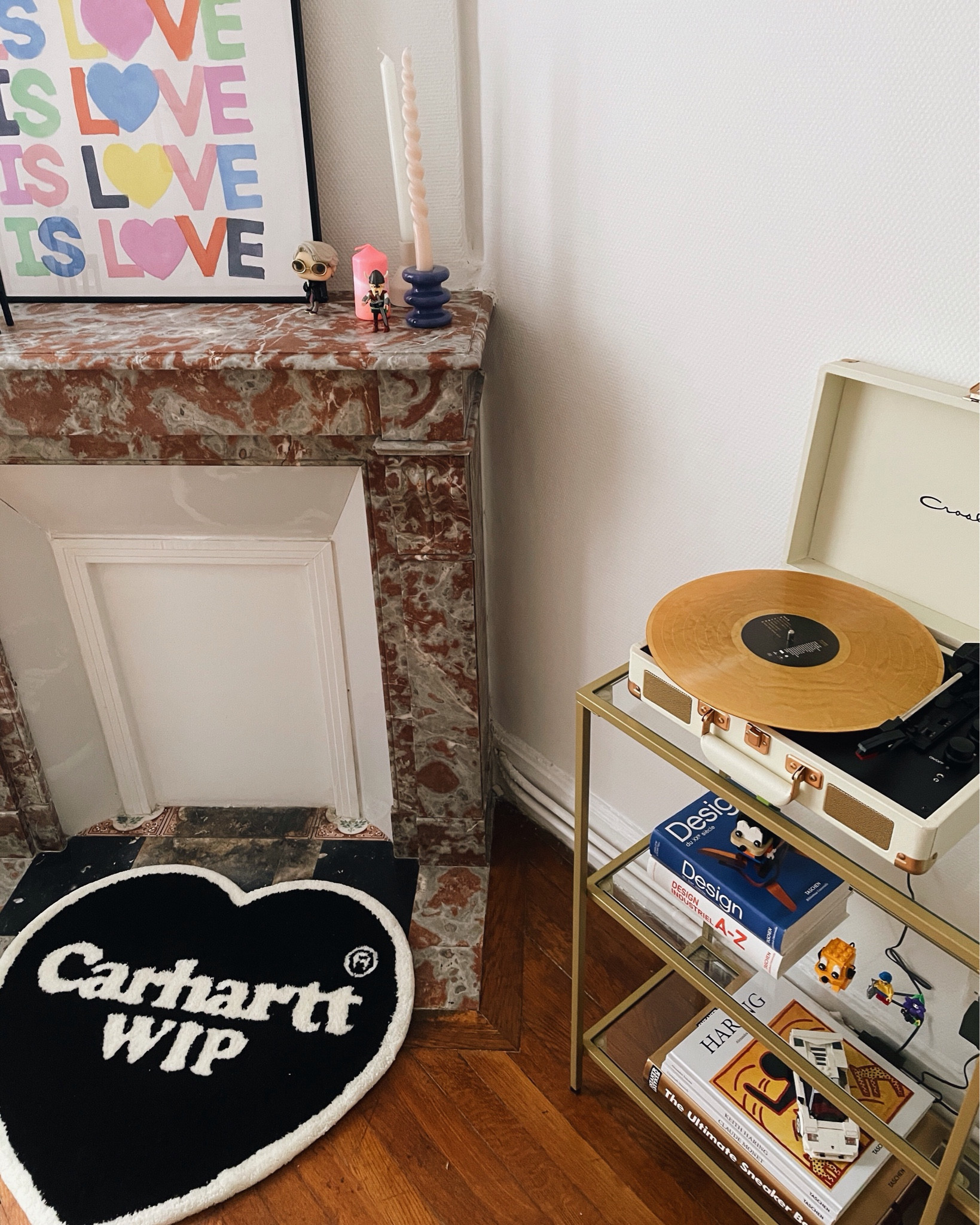 Meuble laiton et verre avec platine et quelques livres sur le design près d’un coin cheminée 

#LTKhome