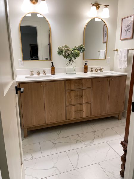 Our master bathroom is one of my most frequented LTK post.  I love the custom white oak vanity and brass finishes.  

Neutral modern bathroom.  Double bathroom vanity.  Gold arched bathroom mirrors.  Brass faucets.  

#LTKhome
