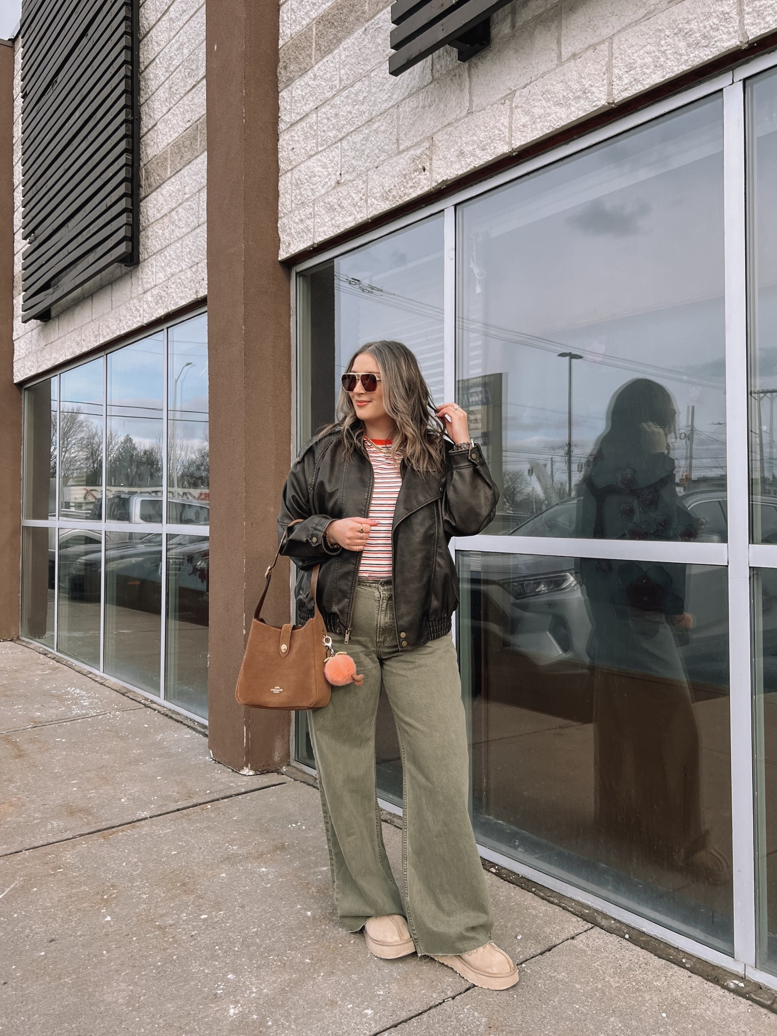 Easy spring outfit! Wearing my usual size L in the leather jacket. Sized up to XL in the striped tee since I have a larger chest and didn’t want it tight. Wearing 32 long in the olive jeans (the long length was a bit too long for me, reg was too short, so I cut the hem for a custom length! Ugg Tazz platforms fit TTS. I wear this coach bag constantly, and the jellycat peach bag charm is so fun for spring!

#LTKstyletip #LTKjeans #LTKmidsize