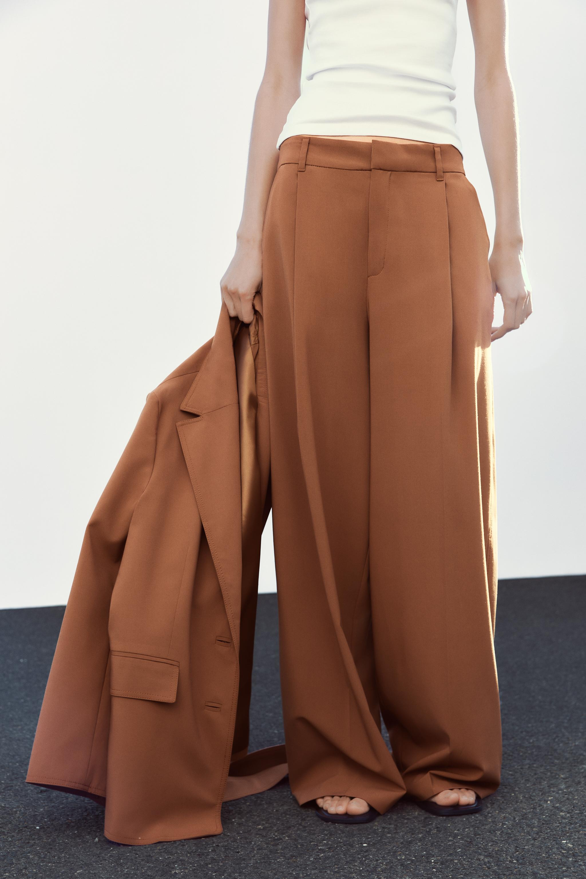 High-waist trousers with belt loops. Pleated detail. Side pockets and false welt back pockets. Zi... | Zara UK