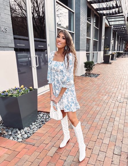 Babydoll dress. White boots. Cowgirl boots. White purse. Chandelier earrings. Blue and white dress. Spring look. 

#LTKFind #LTKSeasonal #LTKstyletip