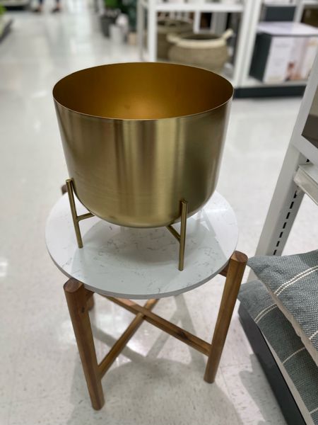 Wood and Marble Accent Table Natural - Threshold 

Brass stand planter showcases your favorite plants in style
Antique gold-toned design with lacquered finish lends an eye-catching vibe
Freestanding design with subtle feet for slight lift


#LTKhome #LTKFind #LTKGiftGuide
