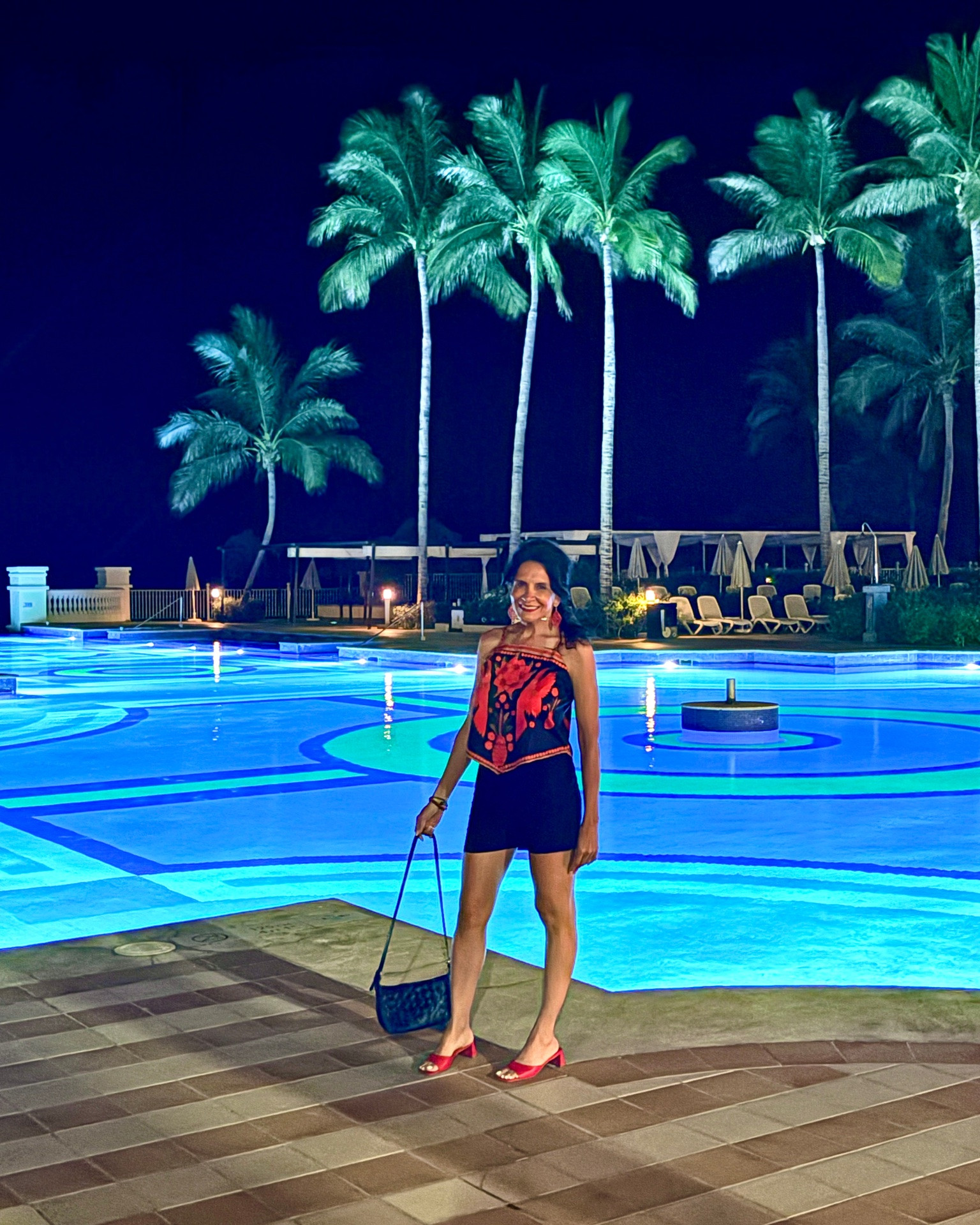This tropical top completely stole my heart! ❤️ It’s lightweight, colorful, and the perfect statement piece for vacation…. easy to dress up or keep casual. Paired with simple shorts and red heels, it was the perfect outfit for strolling the beautiful RIU Palace resort. And can we talk about these breathtaking nighttime views? The glowing pools and palm trees made the evening feel absolutely magical 🌴

Everything I’m wearing is linked in my LTK so you can recreate this vacation look for your next tropical getaway! 🌺🧳

🛍️ Shop my look through the link in my LTK and save it for your next vacation! 💃🏻🏖️ 

#Cutefashion #Tropicaltop

#LTKOver40 #LTKTravel #LTKSaleAlert