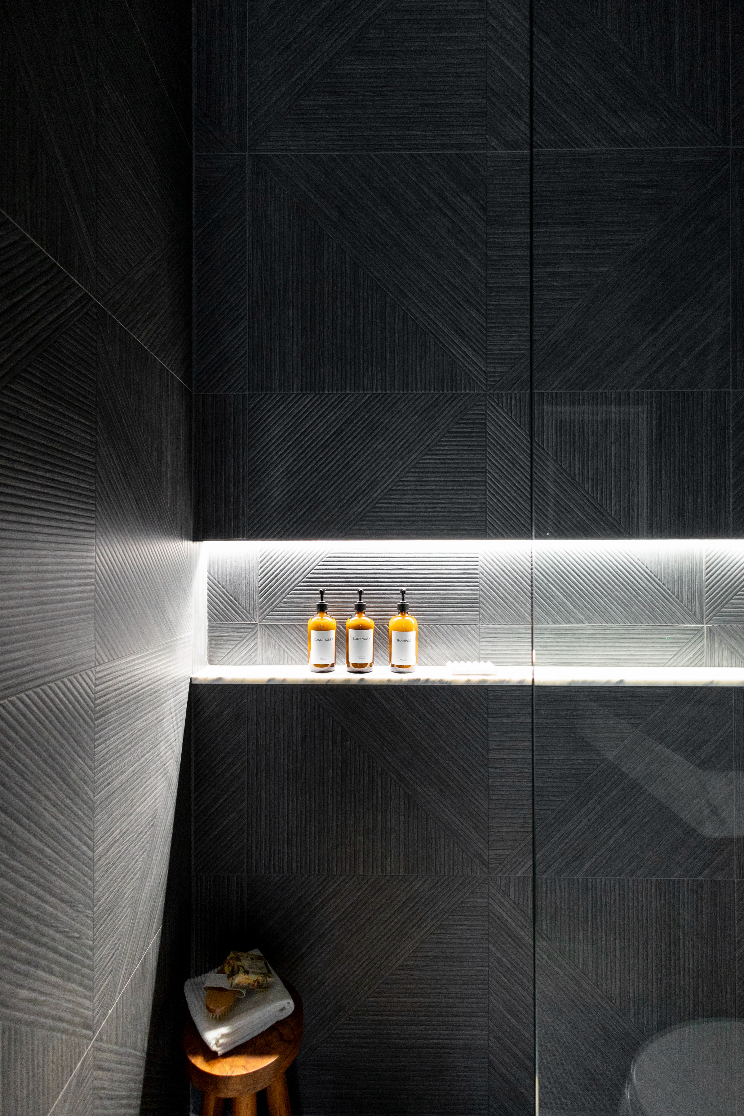 Proof that moody can still feel like a spa🖤 Charcoal tile, bronze finishes and a razor-thin LED niche turn this shower into a five‑star escape—no passport required😉 

 #LTKGiftGuide #LTKHome #LTKStyleTip