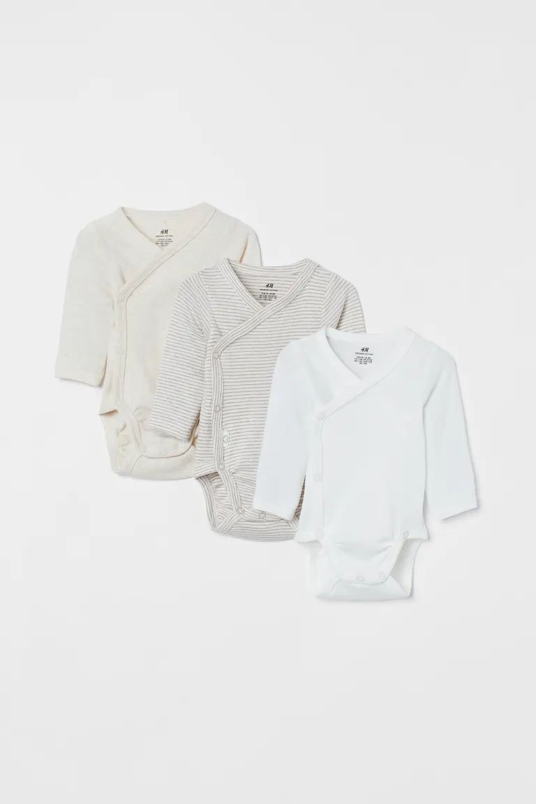 Conscious choice  Long-sleeved bodysuits in soft, organic cotton jersey with a wrapover front. Sn... | H&M (US + CA)