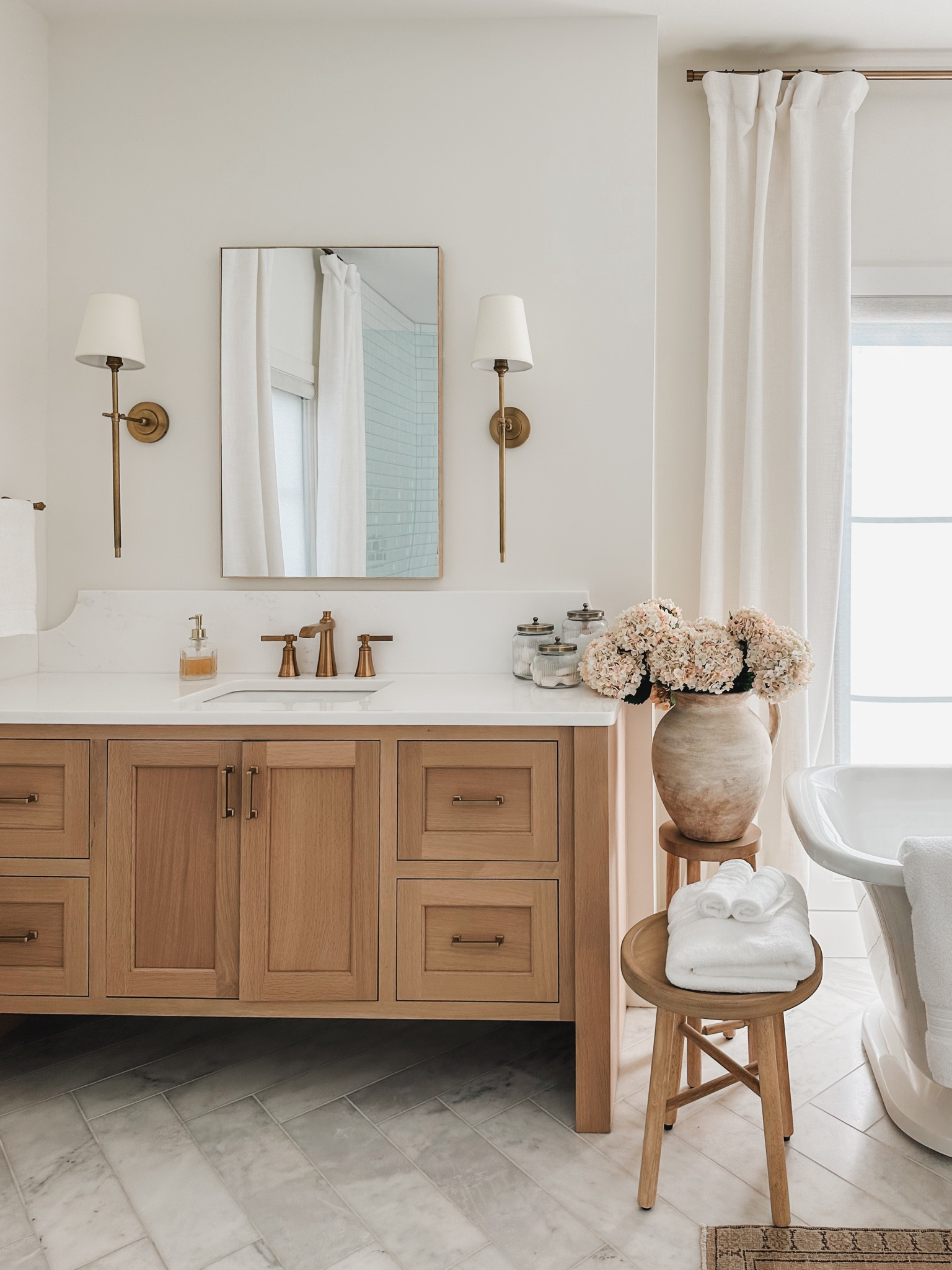 A closer look at my primary bathroom featuring minimal swaps of faux pink florals and oversized vase, neutral wood tone accent tables 

Bathroom refresh, light and bright, neutral style, vintage style rug, gold detail, wall sconce, faux florals, Pottery Barn style, Target style, vase faves, woven basket, neutral wood tone, door knob detail, chandelier faves, tapered candle, curtain detail, gold hardware, shop the look!

#LTKSeasonal #LTKHome #LTKStyleTip