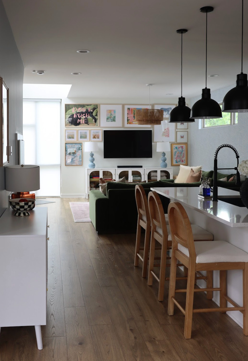 This colorful, modern home is proof that personality and warmth can completely transform a space.✨ With an open floor plan, we were intentional about how we introduced color to keep each area flowing beautifully together. In the living room, a deep green sofa set the tone, layered with a pink rug, an acrylic coffee table, and a gallery wall filled with vibrant travel photos, modern prints, and meaningful personal pieces. The entryway makes a bold first impression with a colorful console and statement artwork, while a chic bar area adds a playful, eclectic touch. The result is a joyful, artful home that feels both modern and deeply personal — a true reflection of the client's story.🎨💚 #eclecticstyle #colorfulhome #moderninteriors
 

 #LTKHome #LTKTravel #LTKFamily