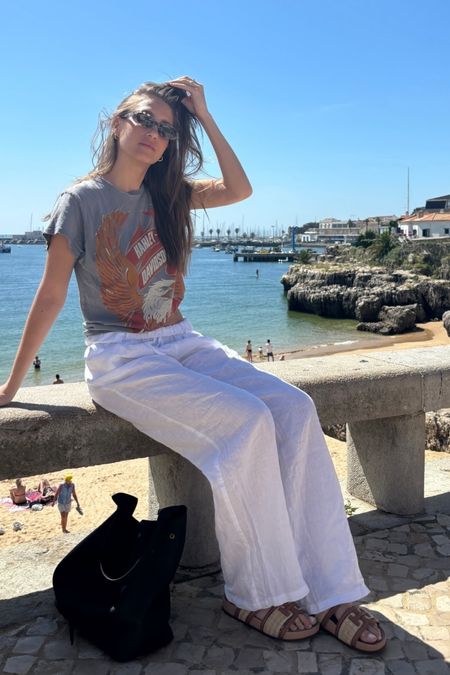 Shop Amanda Batula's graphic print gray vintage style T-shirt top, white linen flow vacation pants, Rafia slip on sandals #CelebrityStyle #AmandaBatula


#LTKFestival #LTKstyletip
