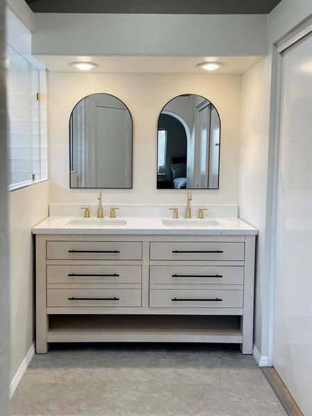 Modern minimalist bathroom with black arched wall mirrors, gold faucets and a gorgeous natural double sink vanity! 

#LTKhome