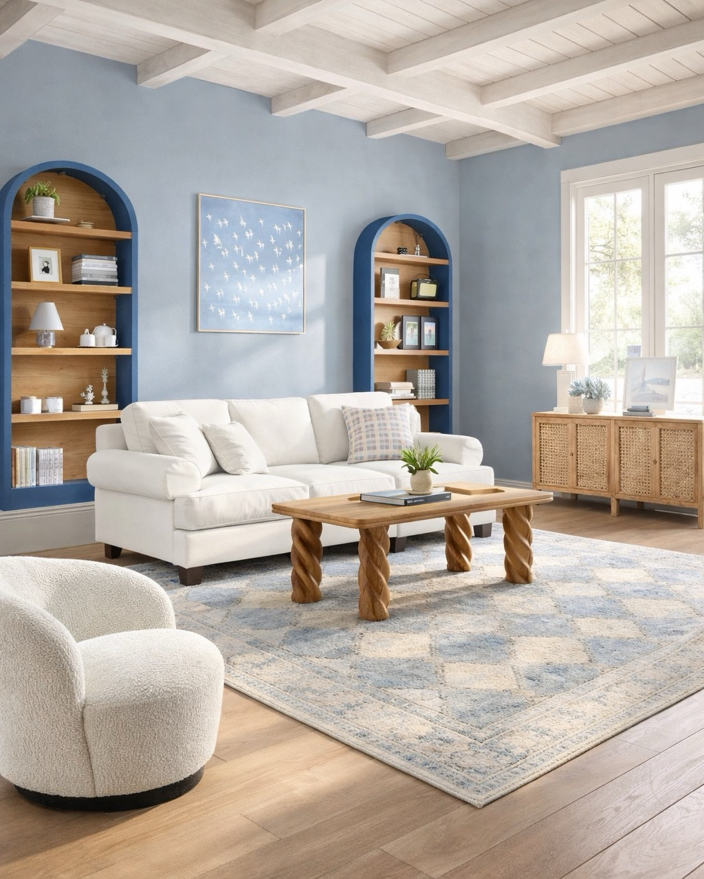 Coastal living room design! Wool rug, white sofa and accent chair. Rattan Buffet, blue arched bookshelves. Wood coffee table and beautiful art by Lulu & Georgia. #homedecor #livingroom 

#LTKHome #LTKSeasonal #LTKSaleAlert