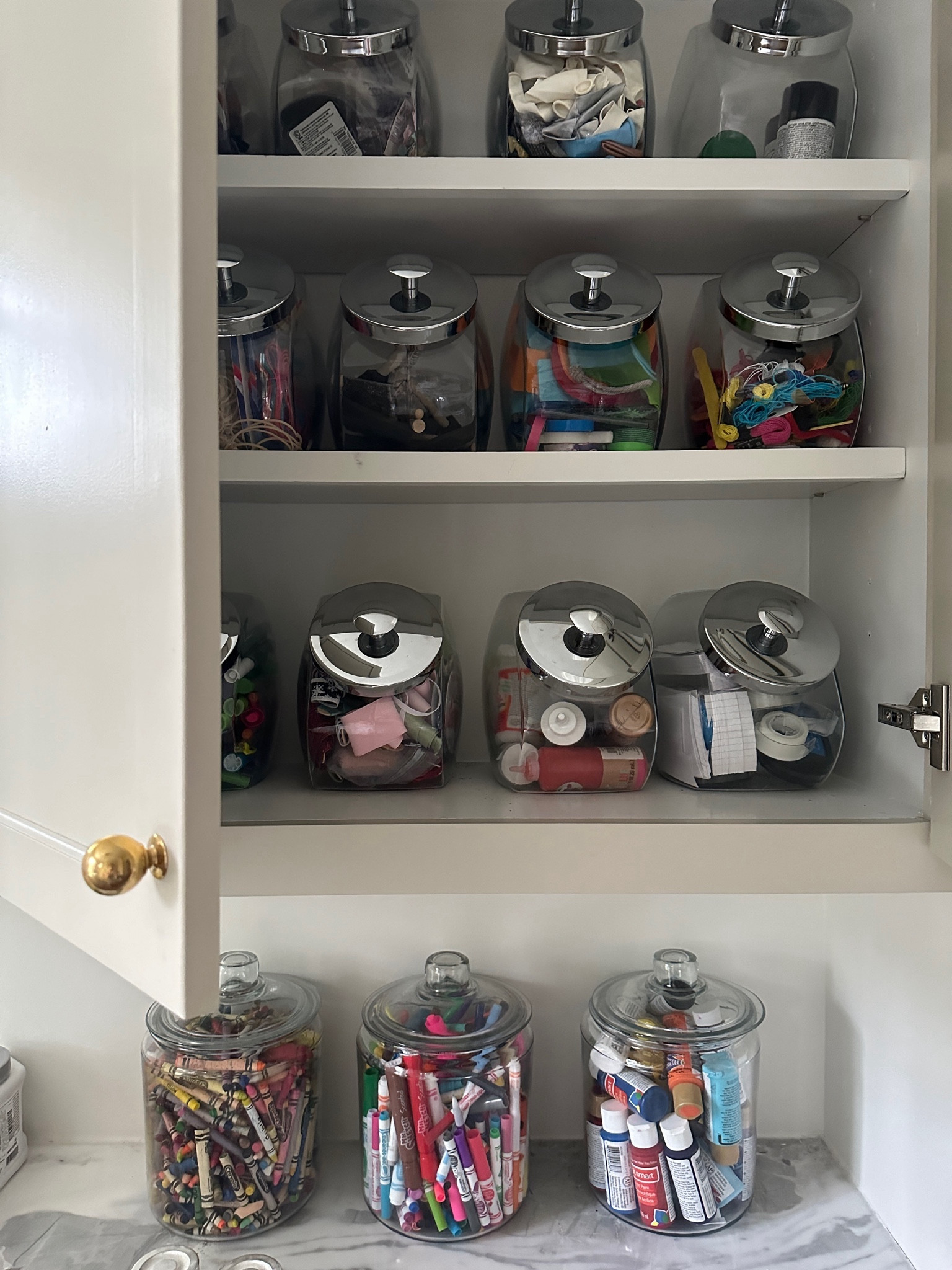 Cabinet storage idea 💡 

Glass penny jars for craft supplies 
Glass jars for markers and crayons 

Laundry room 
Craft room 
Kid art supplies 
Organization 
Storage 

#LTKhome #LTKkids #LTKfamily