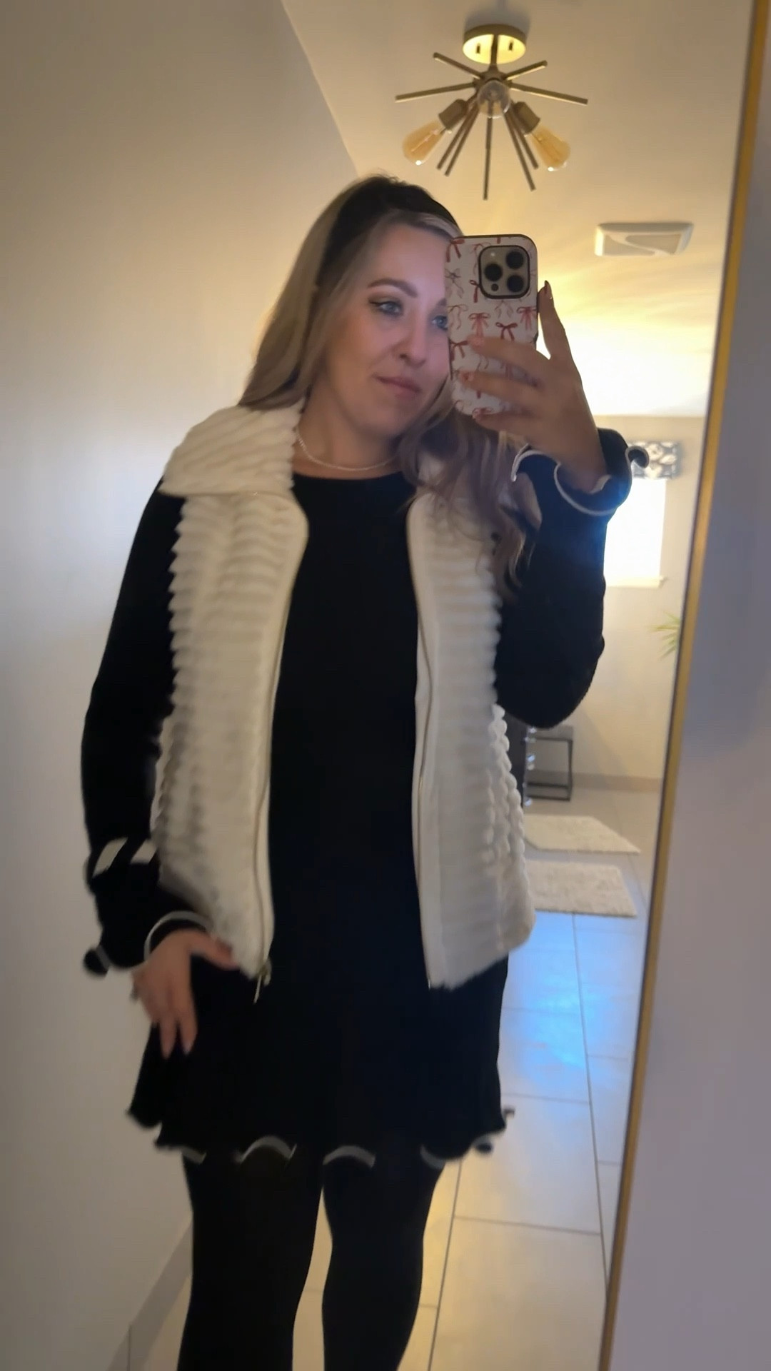 Black mini dress with white ruffle
Ruffle sleeve dress
Sweater dress
Winter outfit
Winter dress
Knit tights
Black Cotten knit tights
White fur zip up vest

#LTKSeasonal #LTKMidsize #LTKHoliday