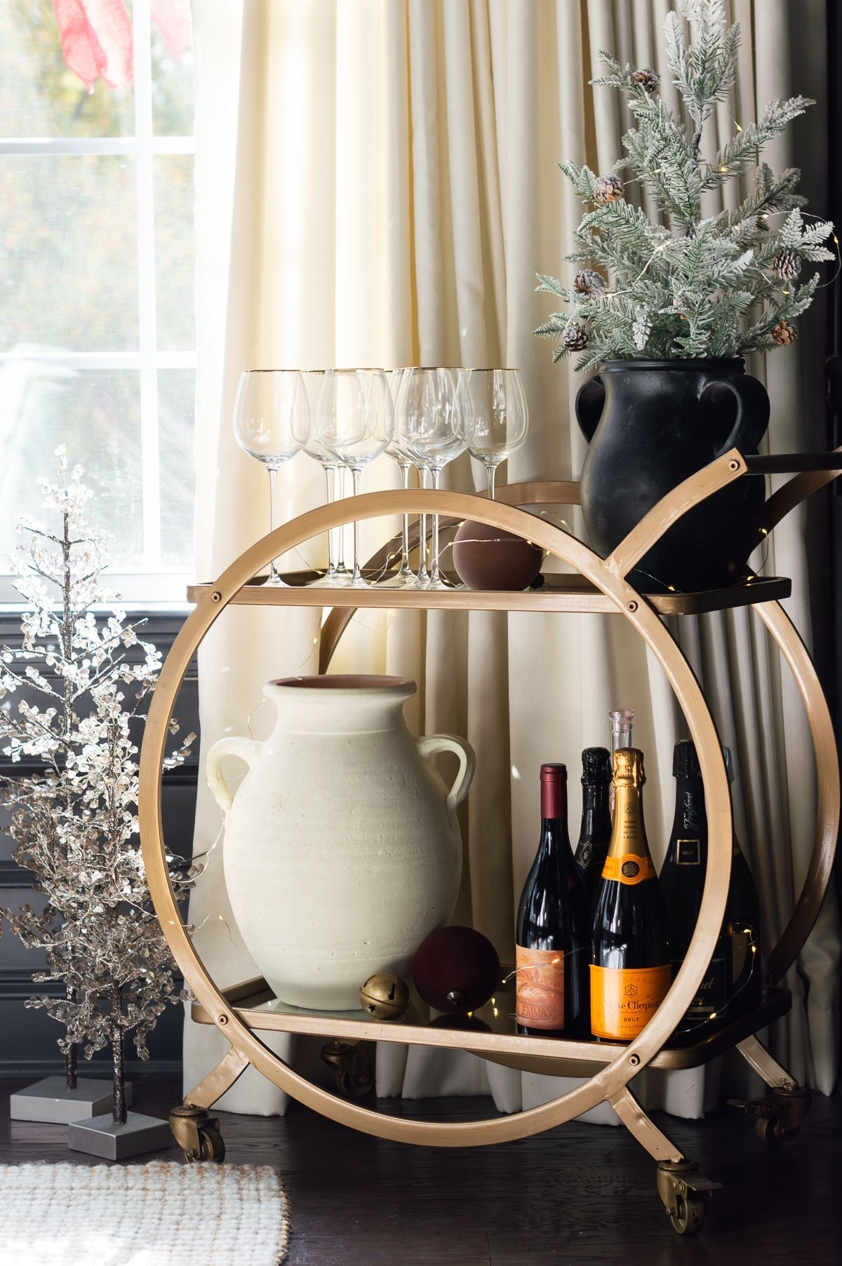 The bar cart in my dining room has two great surfaces to hold hosting supplies and holiday decor. I’ve never tired of its gold finish and circular shape. home decor dining room decor Christmas decor wine glasses twinkle lights black vase

#LTKHome #LTKFindsUnder100 #LTKHoliday