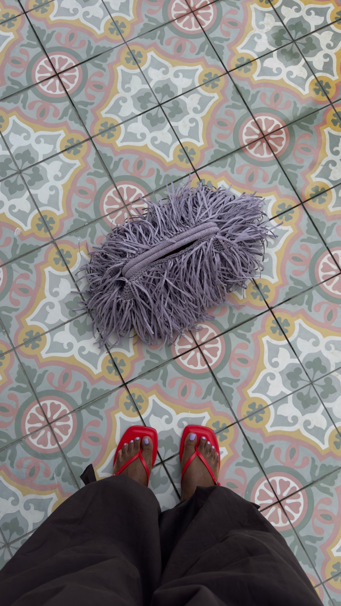 Balloon pants, raffia clutch and red flip flops