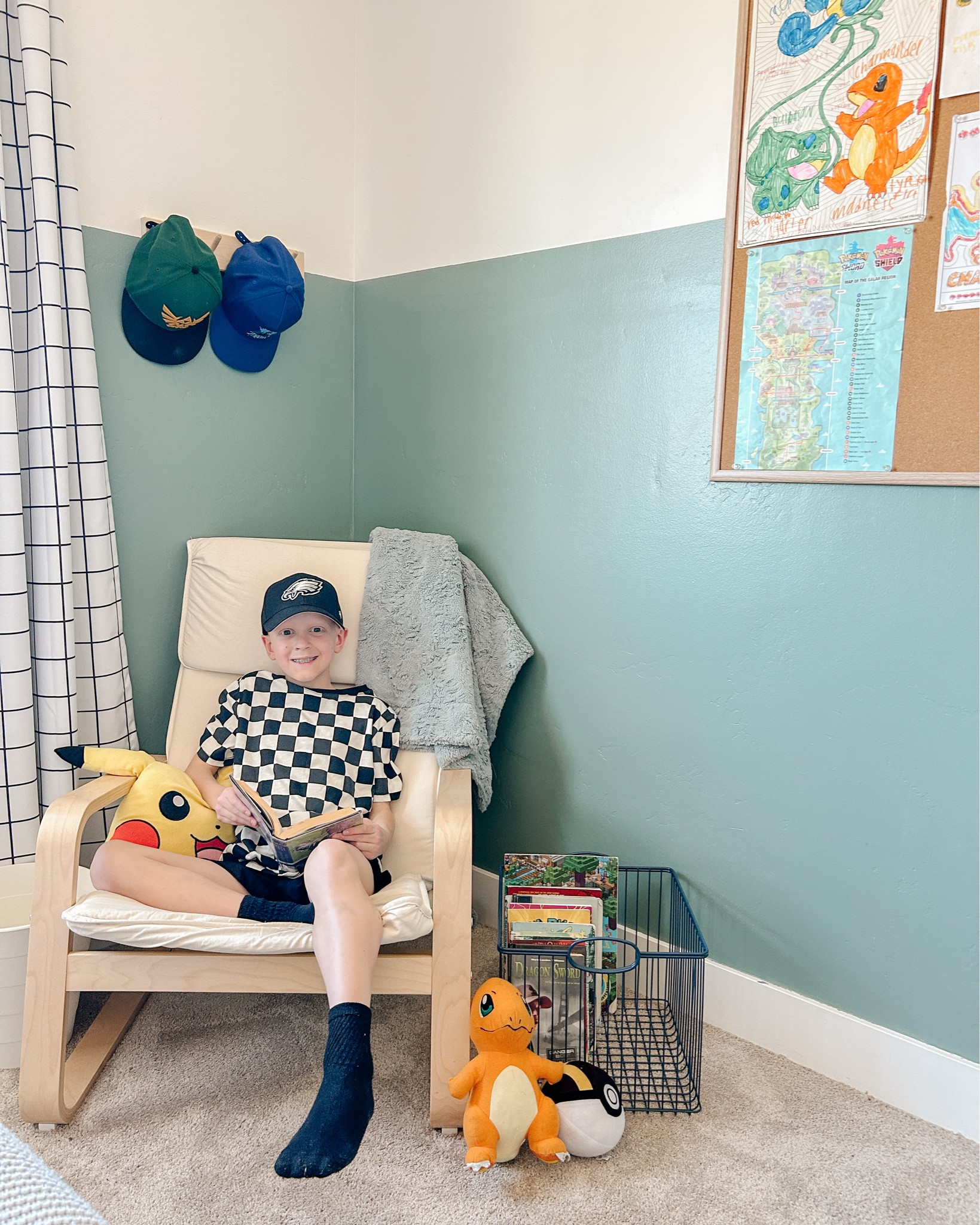 This!!! Just a boy in his new book nook! James is a voracious reader and there are typically stacks of books all over his room! We really wanted a reading space and a place for everything so everything could be put back in its place 😂 Well I really wanted this wire basket for the books! James can spend the evening reading and re-reading his Greek Mythology Graphic Novels and at the end of the night we can quickly throw all the books into the basket and ta-da, his room feels clean again! Dreaming up each space for him has been so fun! 
We love his hat rack too! He also wanted a place to ah g up his drawings - so these jumbo cork boards have been perfect! Last but not least, these black out curtains are the best for a growing boy like James who lives to sleep in! 
Boy room
Tween Boy Room
Book Nook
Kid Room
Pokemon Room

#LTKFamily #LTKKids #LTKHome