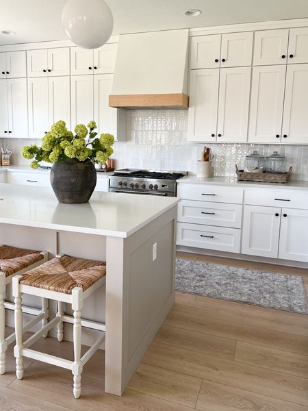 Summer kitchen favorites, spring kitchen decor, white kitchen, Loloi, faux flowers, hydrangeas, Afloral, counter stools, rush seat chairs, white bar stools, blue rug, grey rug, neutral home decor, transitional home, Homebyjulianne 

#LTKhome #LTKsalealert