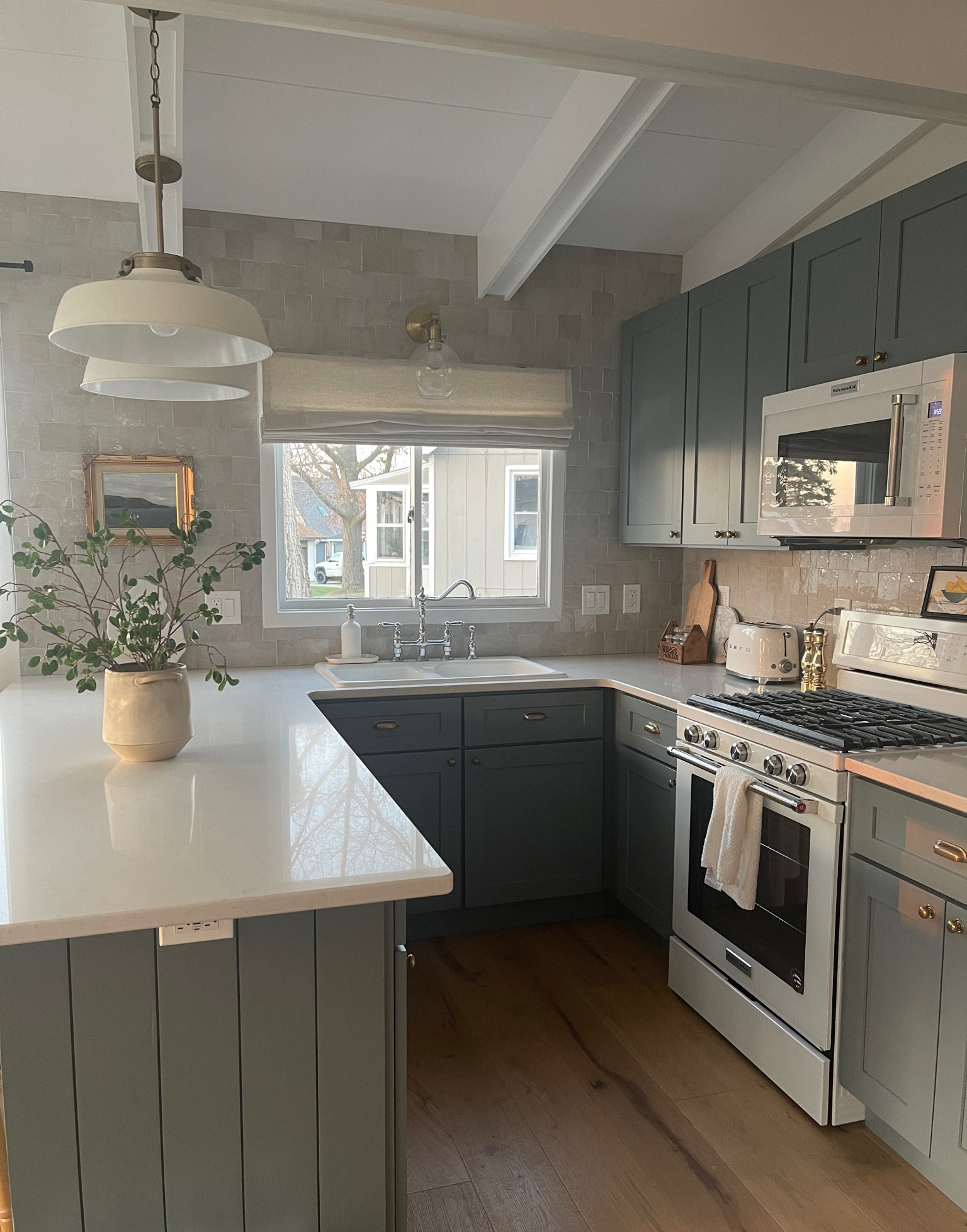 Coastal Kitchen Dreams ✨ 

Exact tile is riad zellige in natural white 4x4. I linked a similar more affordable tile. Roman shade is from select blinds. Linked a similar cast iron sink, mine was from FB marketplace :) 
Cabinets are from Lilly Ann, white shaker elite. Had them painted “Sutton blue” by stoffer home  
#kitchendesign #kitchenaid #pendants #sconce #blue #white #zellige #tile #quartzcountertops #romanshade #kohler #faucet #brass #hardware #shakercabinets #smeg #vintage #art #cafe 

#LTKstyletip #LTKFind #LTKhome