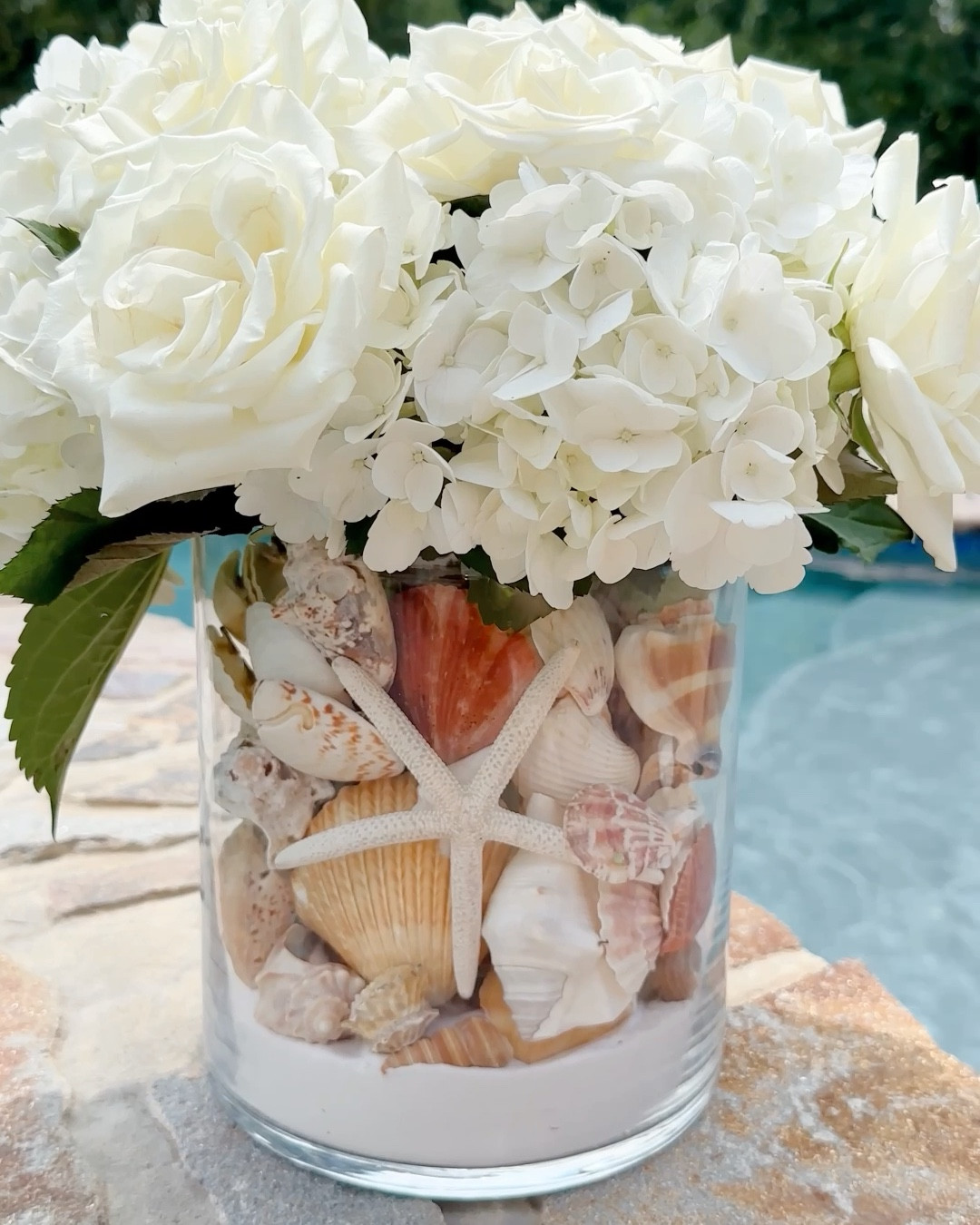 Sand + Seashell Vase 🐚instantly elevates your floral arrangement with a touch of coastal flair.

Celebrate the romance of summer with a stunning arrangement featuring white hydrangeas, white roses, and delicate seashells nestled in a vase with white sand. This elegant combination exudes a timeless and romantic charm, perfect for weddings, special occasions, or simply adding a touch of coastal beauty to your home. 

Coastal decor, summer decor, summer entertaining, seashell centerpiece, coastal home

#LTKStyleTip #LTKHome #LTKSeasonal